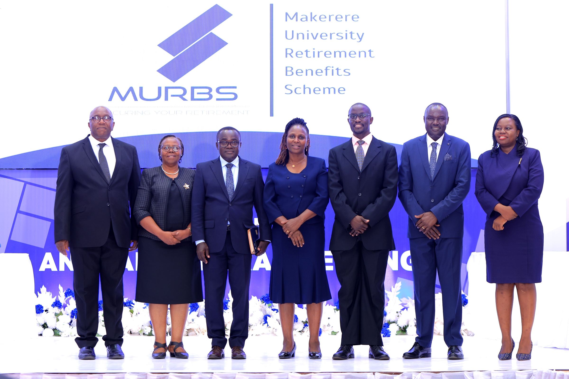 The Chairperson, Dr. Michael Kizito (3rd Right) and Board Secretary, CPA Francesca Angida Mugyema (Centre) with MURBS Trustees from Left to Right: Mr. George Bamugemereire, CPA Edna Rugumayo, Dr. Deus Kamunyu Muhwezi, Mr. Joseph Ikarokok and Dr. Elizabeth Nansubuga at the 15th AGM on 23rd October 2025. Makerere University Retirement Benefits Scheme (MURBS) Board of Trustees on 23rd October 2025 during the 15th Annual General Meeting declared an interest on 13.56% on Members balances for the Financial Year 2024/2025. Main Hall, Main Building, Kampala Uganda, East Africa.