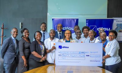 The officials of DFCU Bank and the Scholars Program staff pose in a photo with the 20 Million Shillings dummy cheque donation by DFCU Bank.
