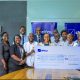 The officials of DFCU Bank and the Scholars Program staff pose in a photo with the 20 Million Shillings dummy cheque donation by DFCU Bank.
