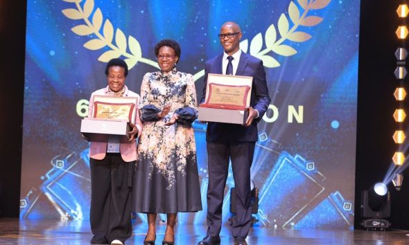 Staff from the Makerere University College of Health Sciences (MakCHS) recognised for their contribution to the health sector in Uganda and beyond during 6th edition of the Heroes in Health Awards (HIHA) held 14th November 2025 during the Africa Health Summit at Kololo Ceremonial Grounds, Kampala Uganda, East Africa. Professor Moses Galukande (Right) and Dr. Mary Nabbosa (Left) with Hon. Dr. Jane Ruth Aceng (Centre) after receiving their respective Minister’s Special Recognition Awards.