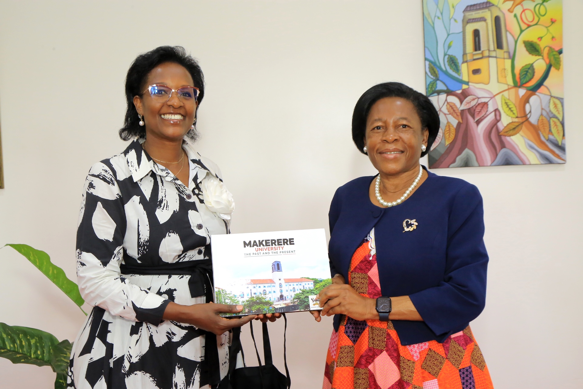 Dr. Lorna Magara gifts H.E. Dorothy Samali Hyuha a Makerere University, centennial coffee table booklet. Celebration of 60 years of diplomatic relations between the Republic of Uganda and the Commonwealth of Australia organized by the Australian Alumni Association of Uganda (A3-U) in partnership with Makerere University and the Australian High Commission, 18th November 2025, Kampala Uganda, East Africa.