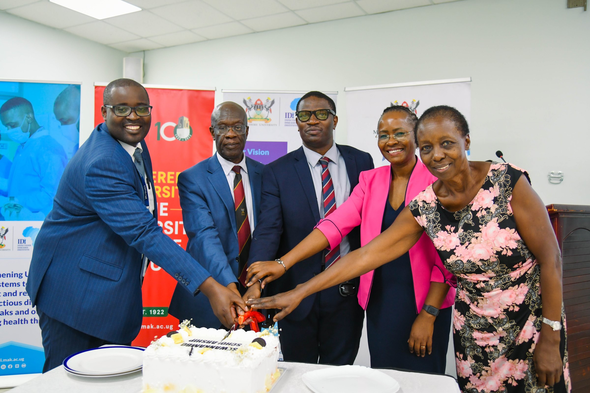Dr. Francis Kakooza (Centre) joins officials in cutting cake to celebrate the launch. Makerere University Infectious Diseases Institute (IDI) unveils second cohort of PhD Fellows and launch of Sewankambo Training Program for Global Health Security, 27th November 2025, Makerere University, Kampala Uganda, East Africa.