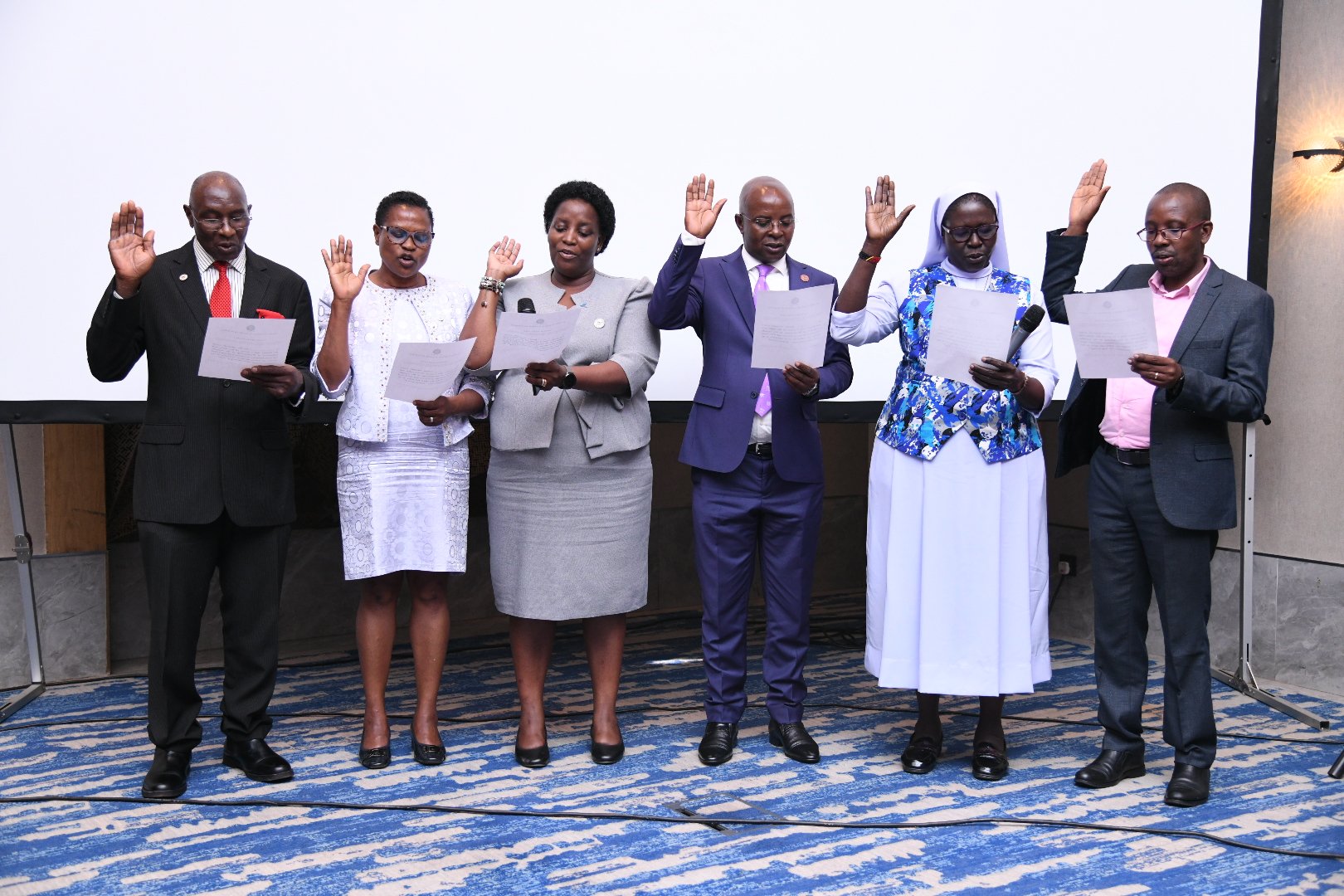 Prof. Edward Bbaale (3rd R) flanked by fellow inductees including Prof. James Kiwanuka-Tondo (L), Prof. Helen Nambalirwa Nkabala (3rd L), Professor Rev. Sr. Dominica Dipio (2nd R), Dr. Amon Ashaba Mwiine (R) takes oath. Professor Edward Bbaale, Principal of the College of Business and Management Sciences (CoBAMS), Makerere University, inducted into the prestigious fellowship of the Uganda National Academy of Sciences (UNAS), 31st October 2025, Kampala Uganda, East Africa.