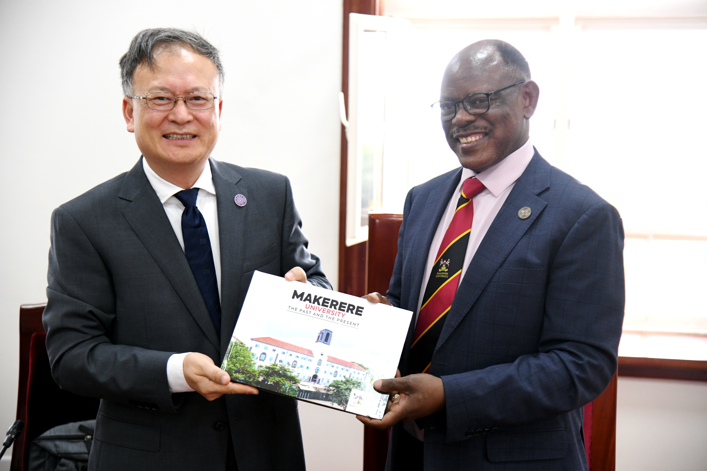 Prof. Barnabas Nawangwe hands over the Makerere University Centennial Coffee table pictorial booklet to Prof. Huan HongYong, Dean, Hefei Institute for Public Safety Research, Tsinghua University. Makerere University high-level meeting between Vice Chancellor Prof. Barnabas Nawangwe and a delegation from Tsinghua University’s Hefei Institute for Public Safety Research, one of China’s leading centres of excellence in disaster prevention, public safety, and emergency management led by Dean Prof. Huan HongYong, Friday December 12, 2025, Makerere University, Kampala Uganda, East Africa.