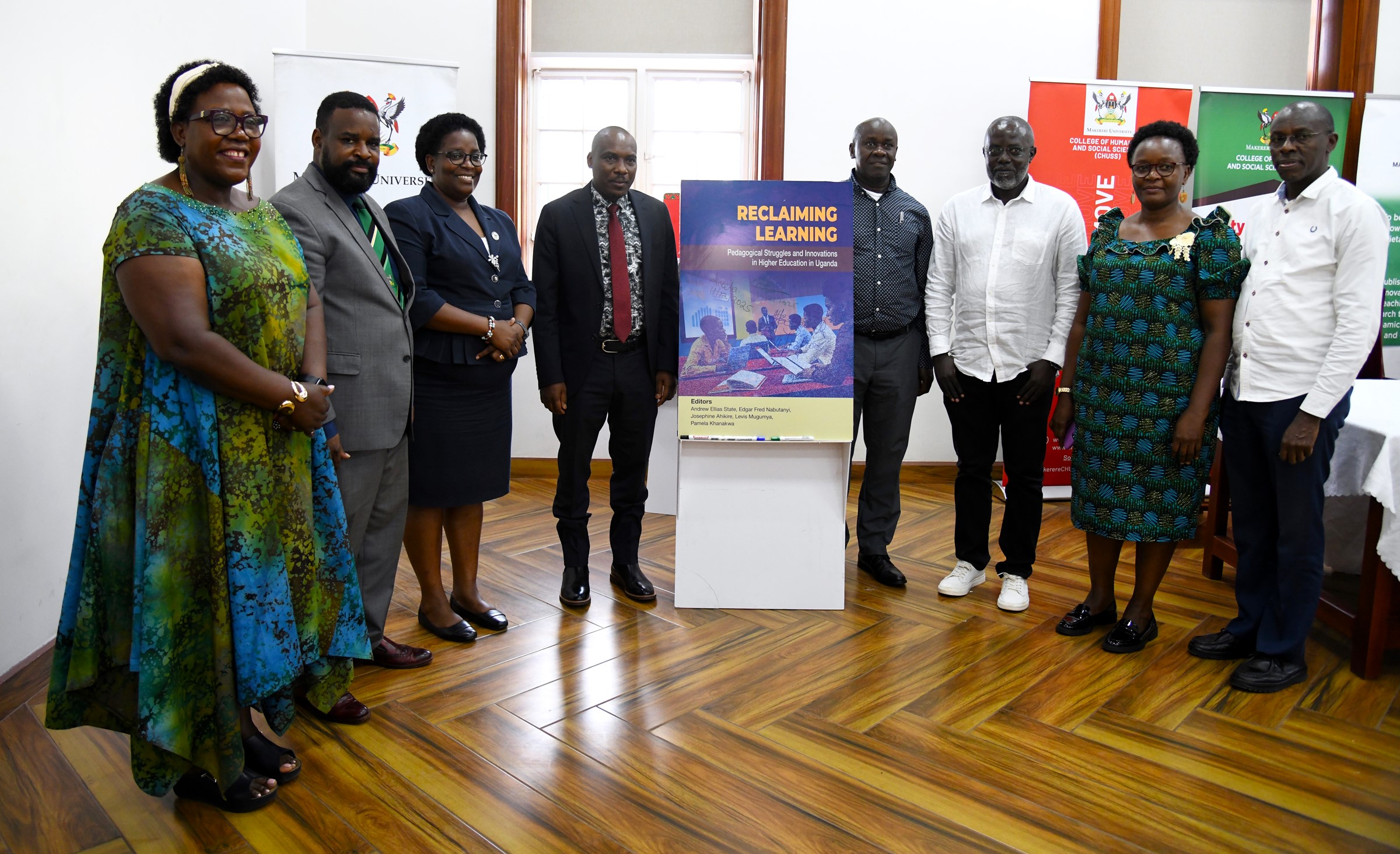 Prof. Winston Tumps Ireeta (4th Left) and Prof. Helen Nambalirwa Nkabala (3rd Left) with Left to Right: Prof. Josephine Ahikire, Prof. Robert Wamala, Prof. Andrew Ellias State, Assoc. Prof. Edgar Nabutanyi, Dr. Pamela Khanakwa, Mr. Tom Tibaijuka with a dummy of the book "Reclaiming Learning" at the event on 11th December 2025. College of Humanities and Social Sciences (CHUSS) on 11th December 2025 celebrated the launch of five scholarly books, marking a significant milestone in the College’s contribution to academic research and discourse, Senior Common Room, Main Building, Makerere University, Kampala Uganda, East Africa.