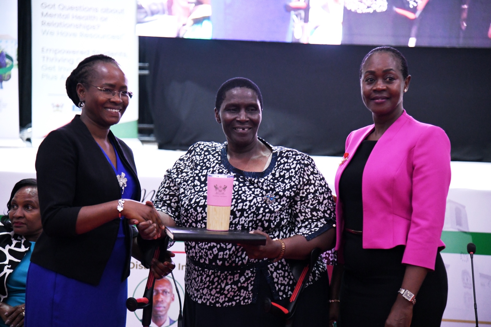 Prof. Sarah Ssali (Left) and Dr. Winifred Kabumbuli (Right) present Mak Souvenirs to Hon. Hellen Grace Asamo (Centre). Makerere University International Day of Persons with Disabilities Celebration, a moment dedicated to reflection on inclusion and shared responsibility organised by the Dean of Students and 91st Guild Ministry of Students with Disabilities, 1st December 2025, Main Hall, Kampala Uganda, East Africa.