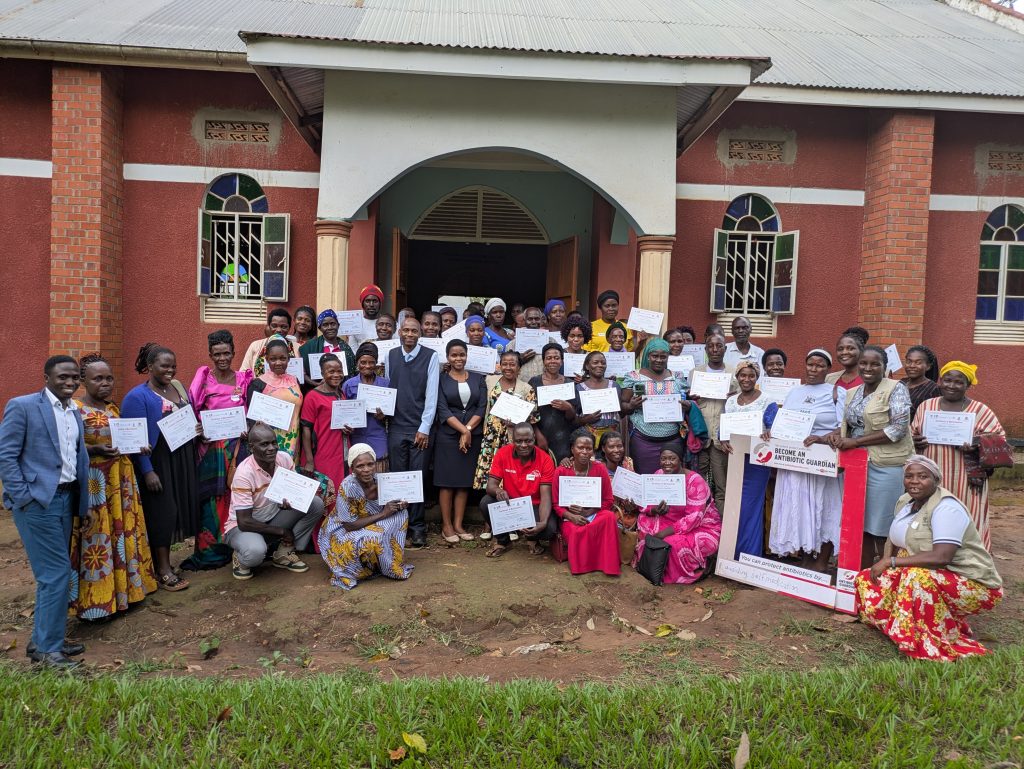 At the centre, Assoc. Prof. David Musoke, one of the lead researchers on the two studies, and Ms. Bonny Natukunda (Senior Health Educator, Wakiso District) pose with community health workers, district health officials, and facilitators after an AMR workshop in Bukondo, Namayumba Sub-County, on September 22, 2025. Delivered under the NTU–Mak Partnership with Buckinghamshire Healthcare NHS Trust, the week-long workshop trained more than 380 community health workers from Namayumba Sub-County.