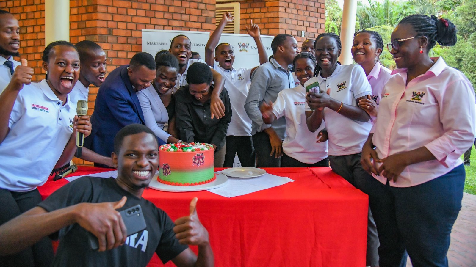 Cake cutting was a true moment of celebration. Makerere University student and staff Safeguarding Champions celebration of Semester One achievements, 28th November 2025, Makerere Institute of Social Research (MISR) Gardens, Kampala Uganda, East Africa.