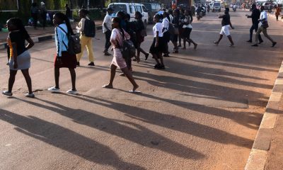 Pedestrians on high alert as they cross the road in Kampala City.