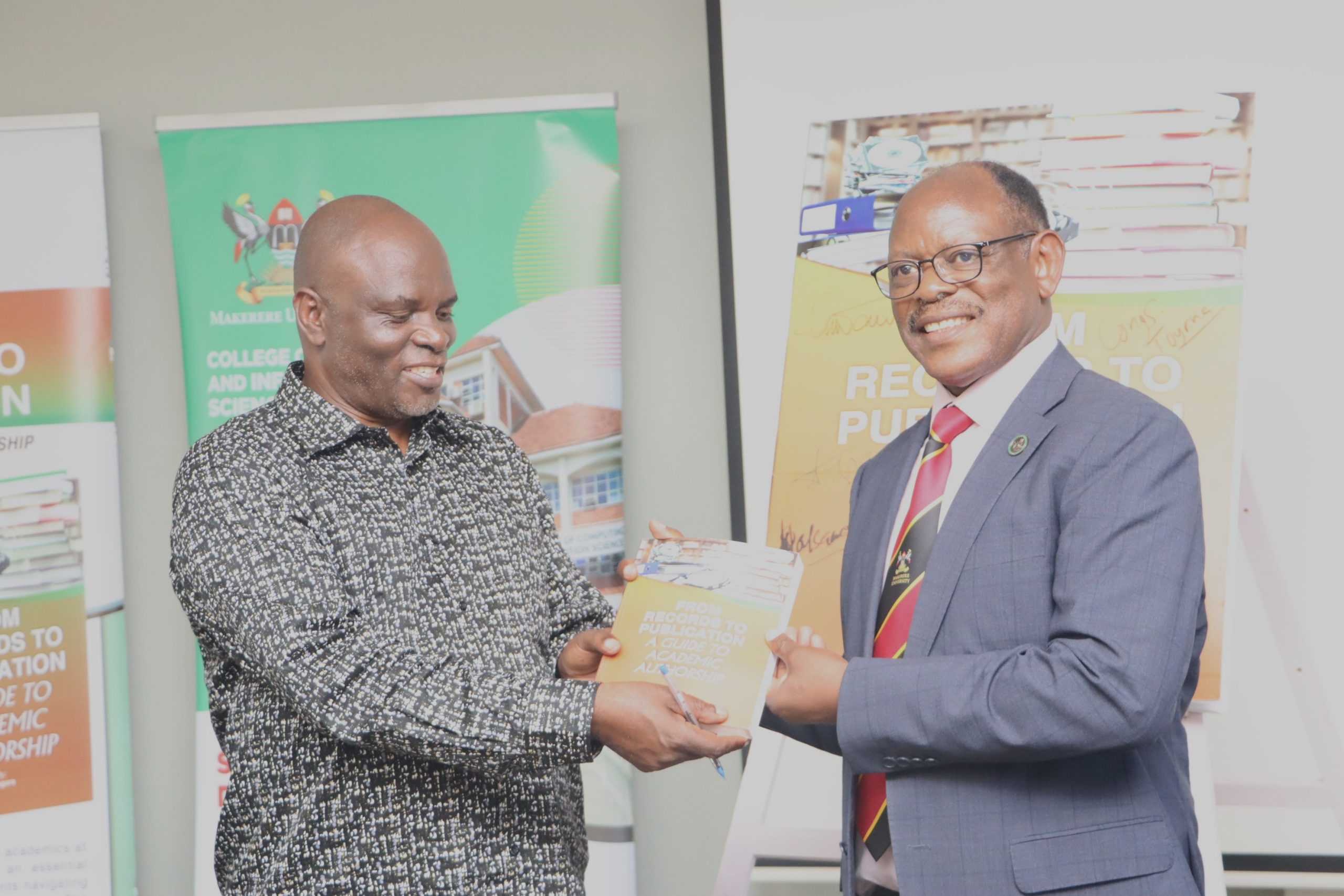 Prof. Elisam Magara hands over the book to Prof. Barnabas Nawangwe. Launch of "From Records to Publication: A Guide to Academic Authorship", by Prof. Barnabas Nawangwe edited by Prof. Elisam Magara of the East African School of Library and Information Sciences (EASLIS), College of Computing and Information Sciences (CoCIS), 12th February 2026, Telepresence Center, Level 2, Senate Building, Makerere University, Kampala Uganda, East Africa.