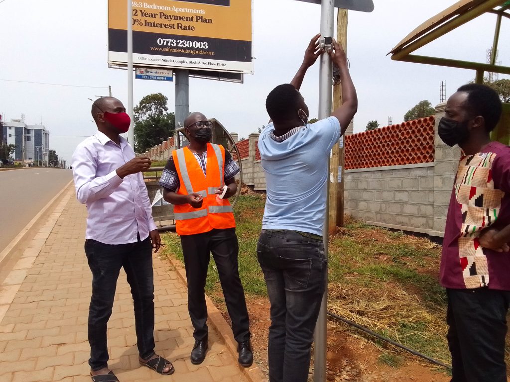 The researcher, Dr. Jimmy Osuret (in an orange reflector jacket), together with his team, mounts video cameras during his PhD study. Makerere University School of Public Health Communications Office, Graduation Profiles Series, 76th Graduation Ceremony, Dr. Jimmy Osuret,Public Health Specialist and Research Associate, Department of Disease Control and Environmental Health, Kampala Uganda, East Africa.