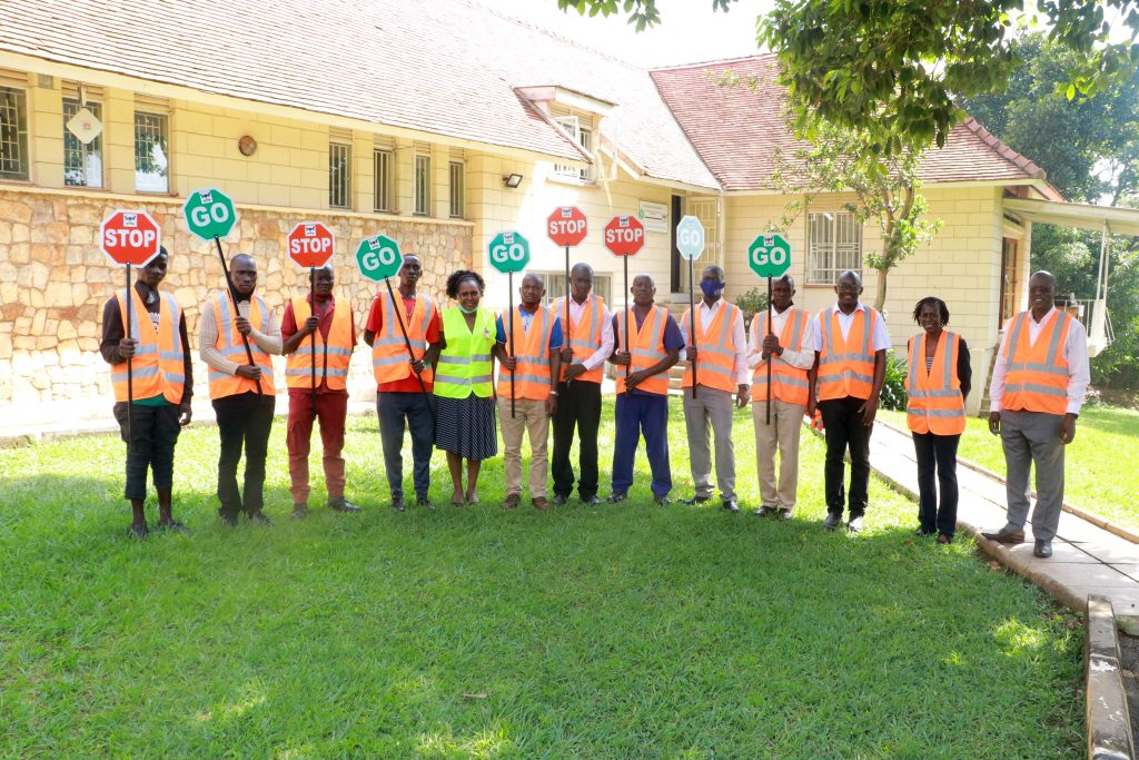 Newly trained School Traffic Wardens stand ready to protect children at busy crossings under Jimmy Osuret’s PhD intervention. Photo by Davidson Ndyabahika. Makerere University School of Public Health Communications Office, Graduation Profiles Series, 76th Graduation Ceremony, Dr. Jimmy Osuret,Public Health Specialist and Research Associate, Department of Disease Control and Environmental Health, Kampala Uganda, East Africa.