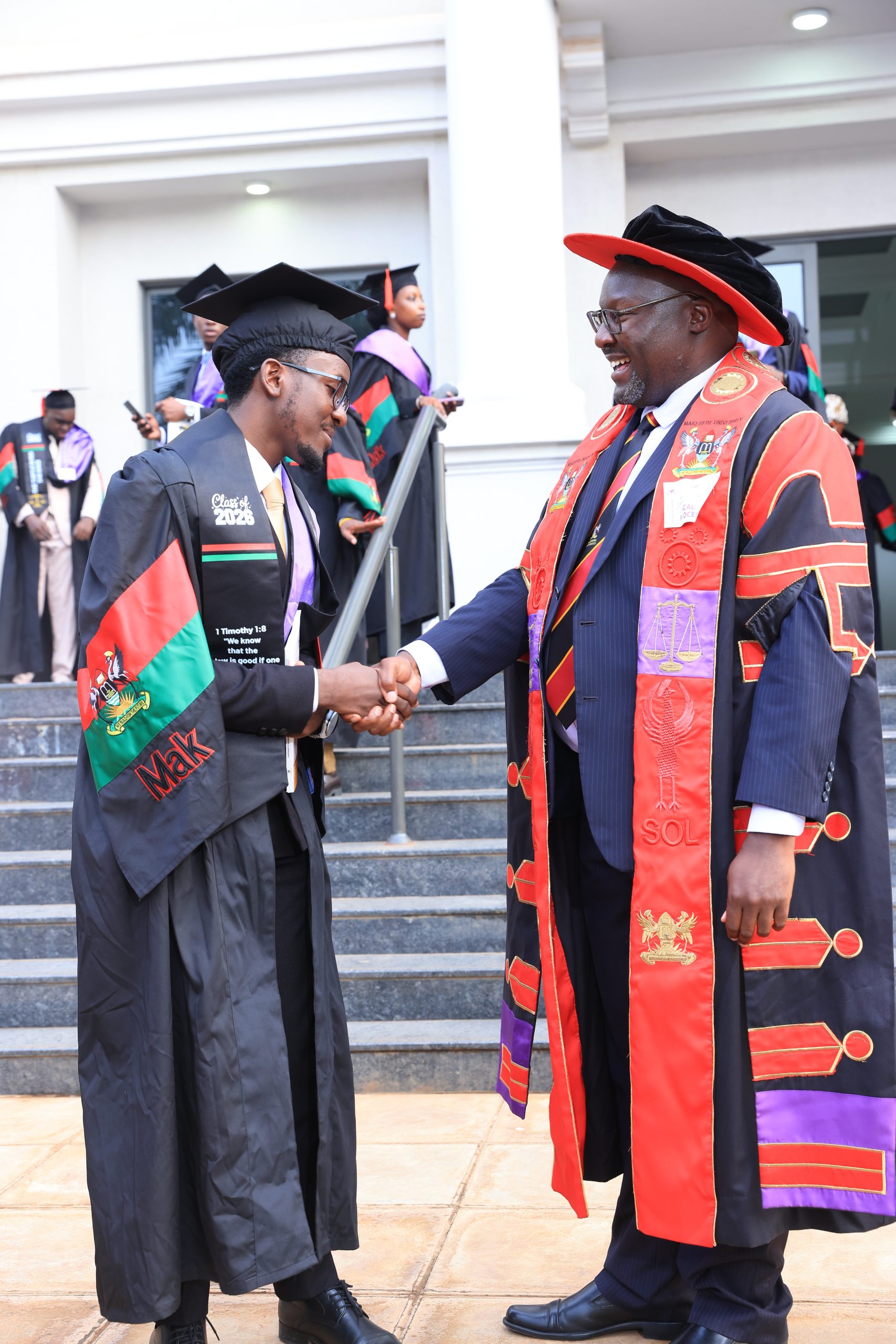 The Principal SoL, Prof. Naluwairo congratulating Aijuka Allan upon successful completion. 76th Graduation Ceremony, Day 1, School of Law (SoL). Commencement Speaker-Prof. Nicholas Ozor, the Executive Director of the African Technology Policy Studies Network, Nairobi, Kenya. 24th February 202, Freedom Square, Makerere University, Kampala Uganda, East Africa.