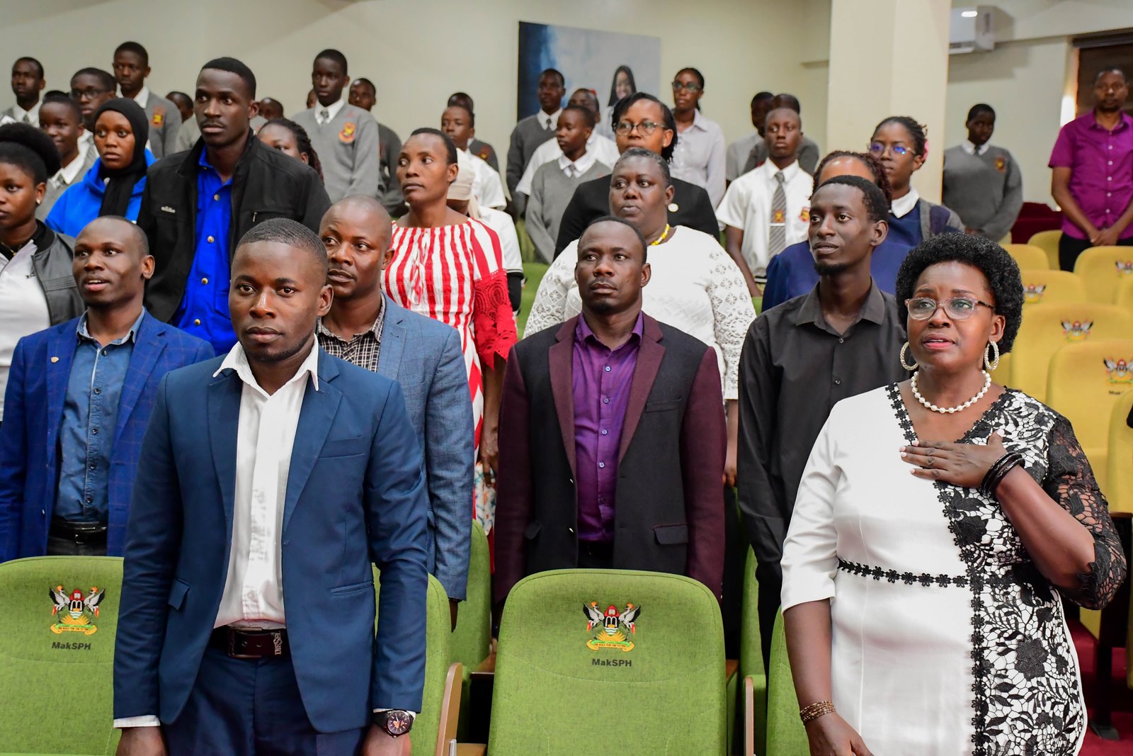 Dr. Anne Ampaire and other participants following the tunes of the respective Anthems. School Stakeholders’ Exhibition, bringing together learners, teachers, researchers, and education policymakers to demonstrate how Uganda’s Competence Based Curriculum (CBC) can be implemented through experiential learning and real-life situations, by graduate students of College of Education and External Studies (CEES) and College of Humanities and Social Sciences (CHUSS) guided by Dr. Anne Ampaire, 26th March 2026, Makerere University School of Public Health Auditorium, Kampala Uganda, East Africa.