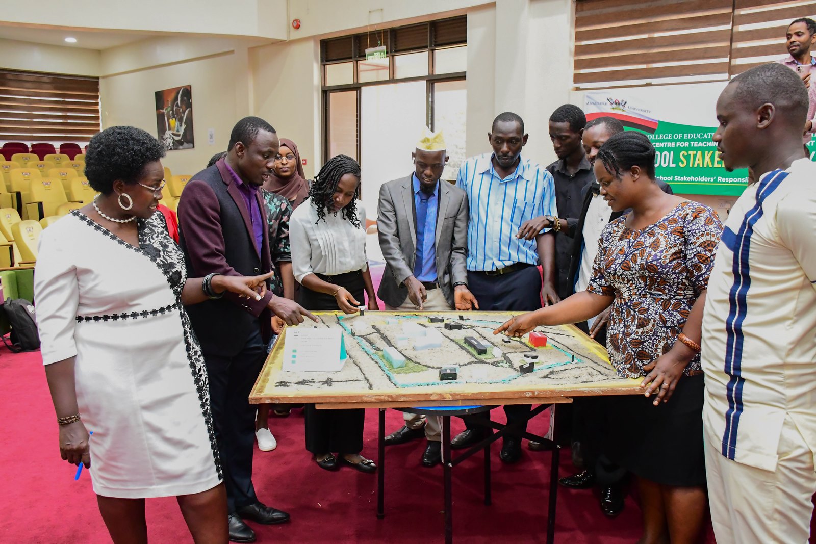 Dr. Anne Ampaire demonstrates the sand strategy model as a CBC approach detailing the map of Makerere University, access points and key features during the event on 26th March 2026. School Stakeholders’ Exhibition, bringing together learners, teachers, researchers, and education policymakers to demonstrate how Uganda’s Competence Based Curriculum (CBC) can be implemented through experiential learning and real-life situations, by graduate students of College of Education and External Studies (CEES) and College of Humanities and Social Sciences (CHUSS) guided by Dr. Anne Ampaire, 26th March 2026, Makerere University School of Public Health Auditorium, Kampala Uganda, East Africa.