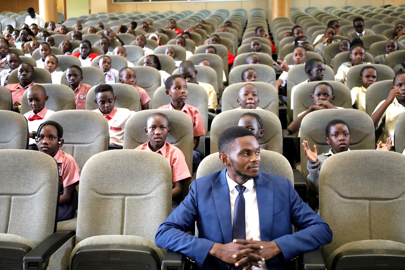 John Robert Tenywa seated with pupils. Inaugural Schools Environmental Conference organised by the Environment for Development (EfD) Uganda in partnership with the Green Vests Initiative, the National Environment Management Authority (NEMA), and the Kampala Capital City Authority (KCCA), theme “Strengthening Environmental Stewardship in Schools”, 20th March 2026, Yusuf Lule Central Teaching Facility Auditorium, Makerere University, Kampala Uganda, East Africa.