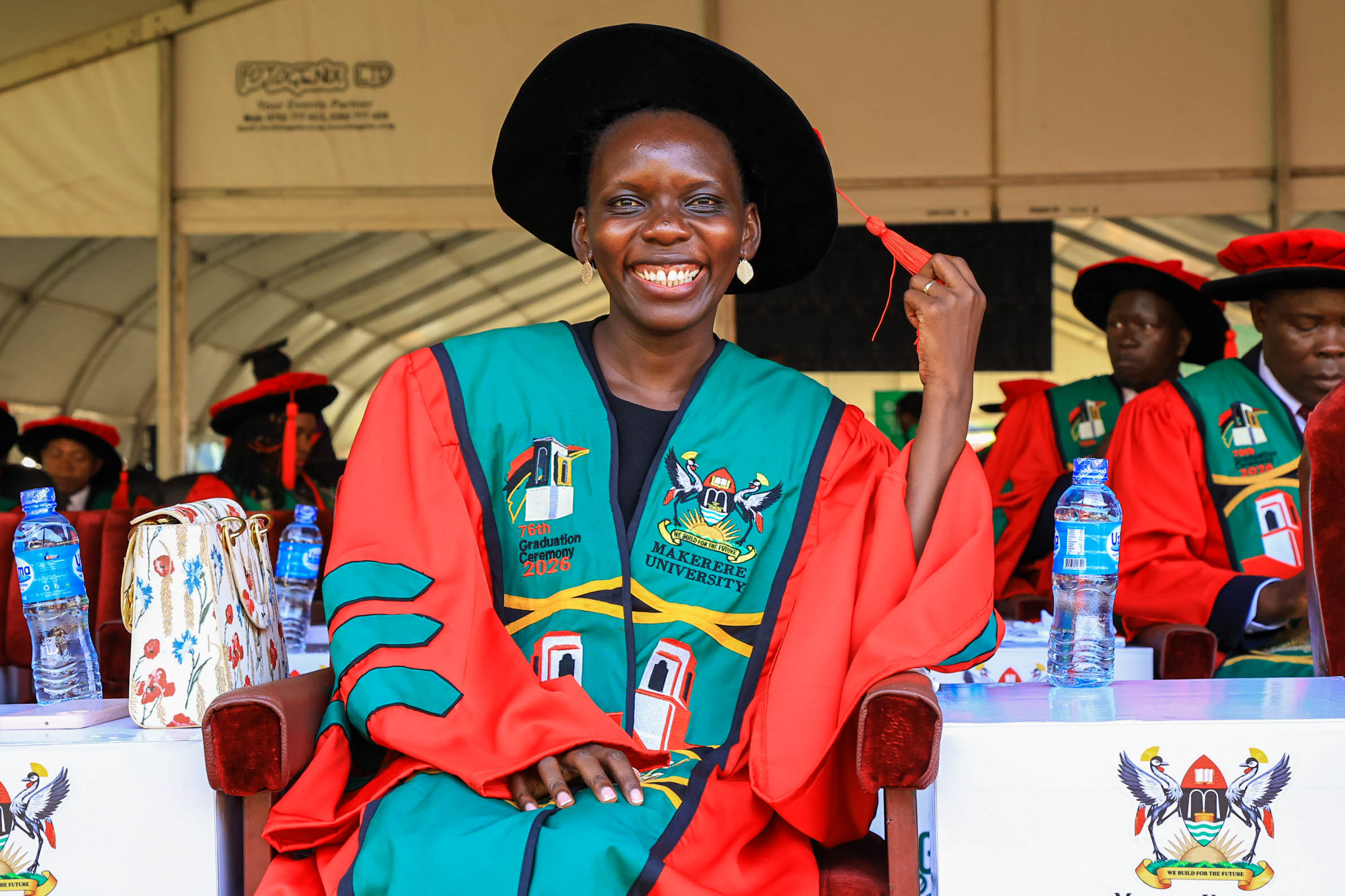 Dr. Harriet Aber Ondoga takes her seat in the Freedom Square during Makerere University’s 76th Graduation Ceremony on February 25, 2026. Makerere University School of Public Health Communications Office, Graduation Profiles Series, 76th Graduation Ceremony, Dr. Harriet Aber Odonga, “Substance Use among Children in Mbale, Uganda: Health System Landscape and Support Structures,” Kampala Uganda, East Africa."