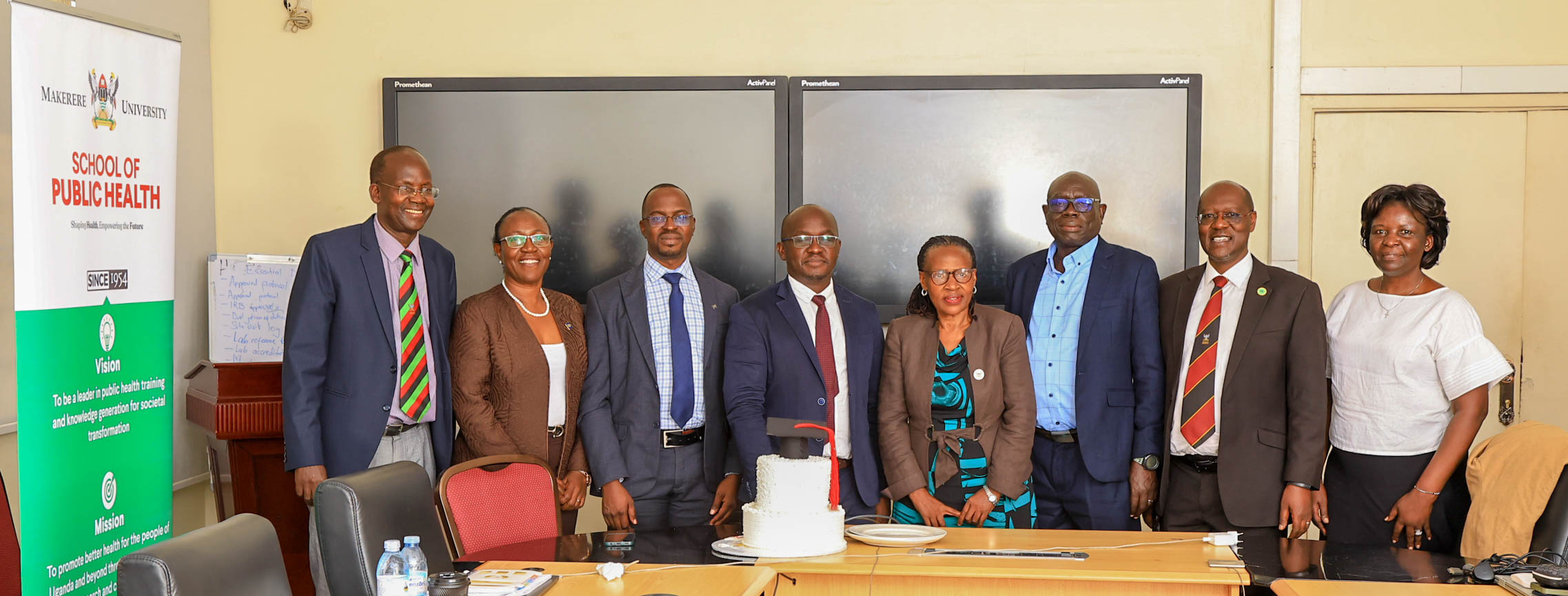 At the centre, Henry Komakech stands next to his Opponent, Prof. Stella Neema, celebrating the successful defence of his doctoral thesis, alongside members of his examining team: External Examiner Dr. Stephen Langole, Internal Examiner Dr. Aloysius Ssennyonjo and Supervisors Prof. Christopher Garimoi Orach and Dr. Lynn M. Atuyambe, and Doctoral Committee member Dr. Juliet Kiguli. The defence meeting was chaired by Assoc. Prof. Christine Nalwadda, Head, Department of Community Health and Behavioural Sciences, on December 19, 2025. Makerere University School of Public Health Communications Office, Graduation Profiles Series, 76th Graduation Ceremony, Dr. Henry Komakech, “Effects of the Repatriation of Refugees on the Health Services of the Host Populations in the West Nile Districts of Arua, Moyo, and Adjumani,” Kampala Uganda, East Africa.