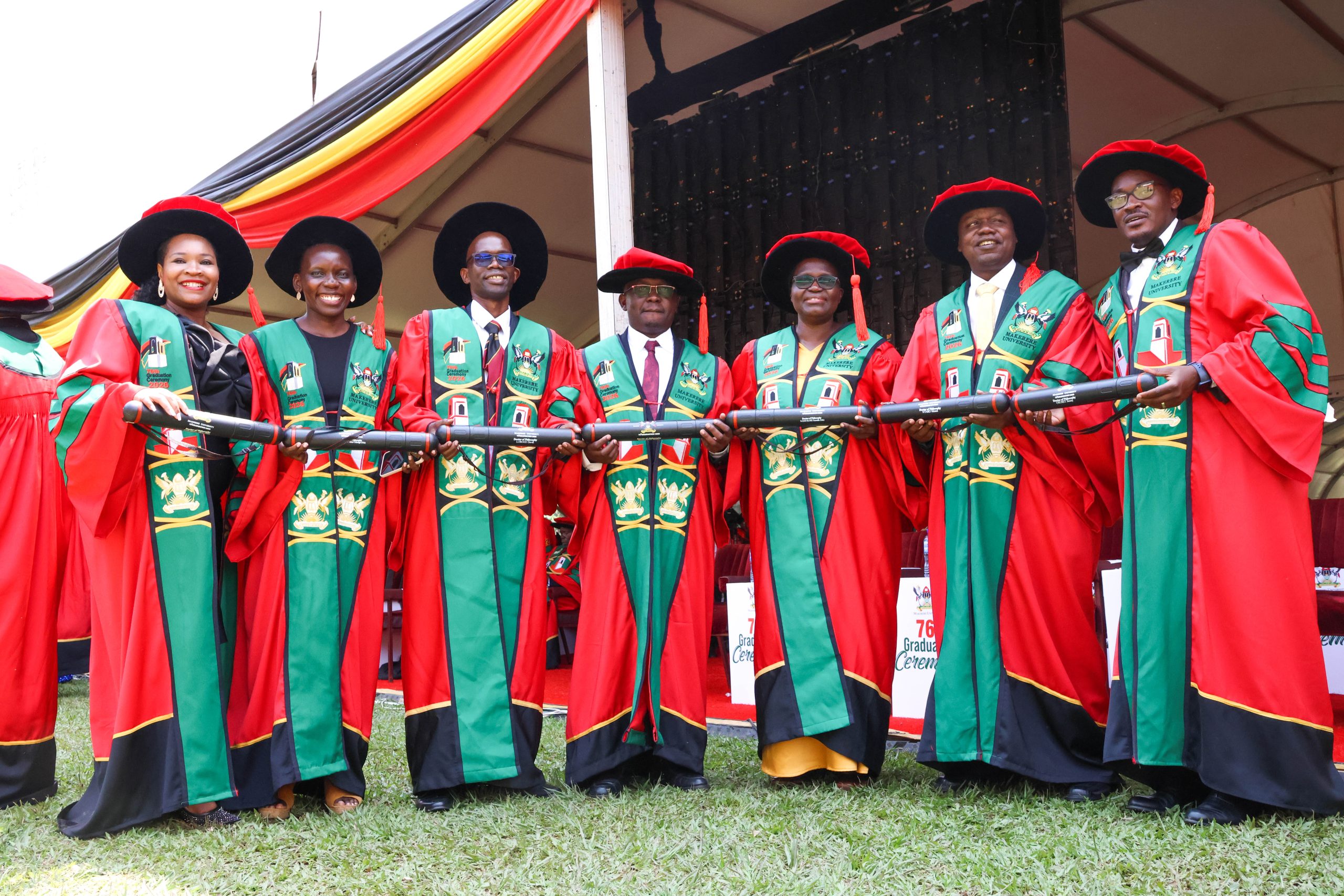 Dr. Henry Komakech (centre) stands with fellow MakSPH PhD graduands at Makerere University’s 76th Graduation Ceremony (L–R): Dr. Olivia Nakisita, Dr. Aber Harriet Odonga, Dr. David Lubogo, Dr. Samalie Namukose, Dr. Moses Ntaro and Dr. Jimmy Osuret. February 25, 2026, Freedom Square, Makerere University. Makerere University School of Public Health Communications Office, Graduation Profiles Series, 76th Graduation Ceremony, Dr. Henry Komakech, “Effects of the Repatriation of Refugees on the Health Services of the Host Populations in the West Nile Districts of Arua, Moyo, and Adjumani,” Kampala Uganda, East Africa.