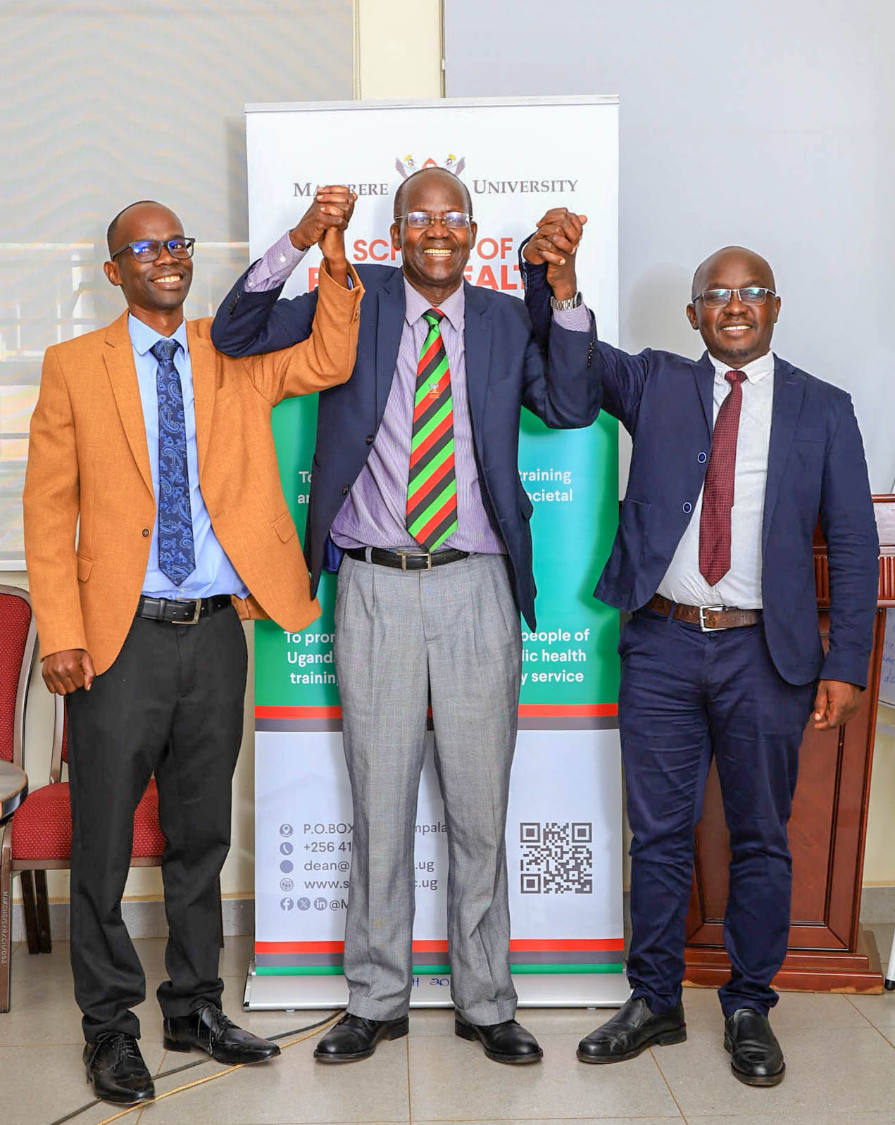 Prof. Garimoi Orach stands in jubilation with his doctoral supervisees, Henry Komakech (right) and Dr. David Lubogo (left), following the successful defence of Komakech’s PhD thesis at Makerere University on December 19, 2025. It reflects Orach’s decades of contribution to mentoring scholars and advancing refugee health and public health in complex emergencies. Makerere University School of Public Health Communications Office, Graduation Profiles Series, 76th Graduation Ceremony, Dr. Henry Komakech, “Effects of the Repatriation of Refugees on the Health Services of the Host Populations in the West Nile Districts of Arua, Moyo, and Adjumani,” Kampala Uganda, East Africa.