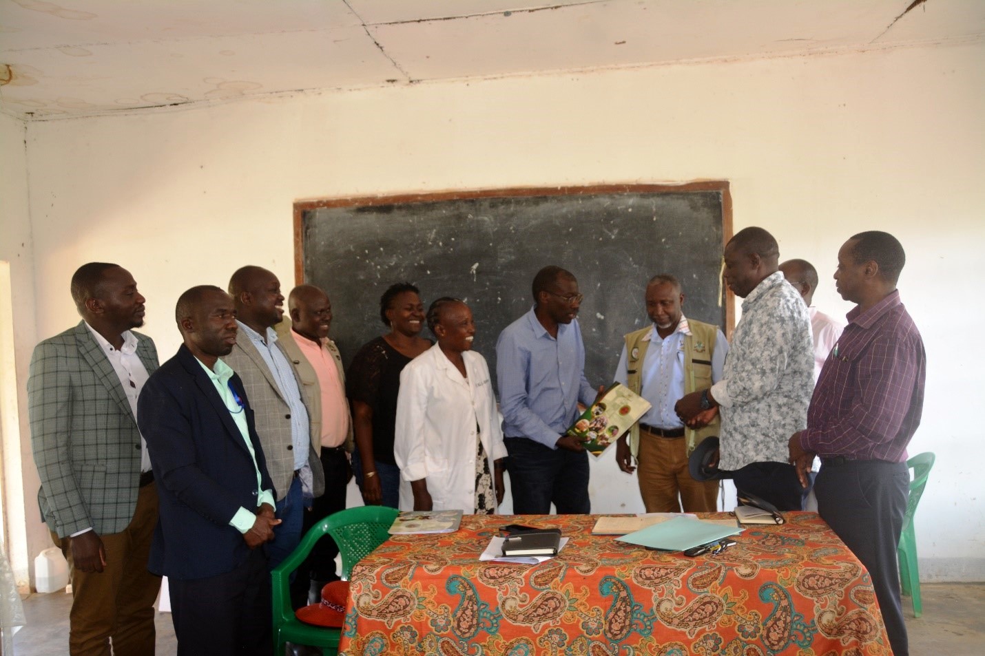 Prof. Frank Norbert Mwiine (in blue) officially hands over the management of Buyana Stock Farm to committee chair Amanya James during the handover ceremony. Hand over of management of livestock farms by College of Veterinary Medicine, Animal Resources and Biosecurity to a newly constituted Select Committee of Council chaired by Amanya Henry, 26th March 2026, Buyana Stock Farm, Mpigi Uganda, East Africa.