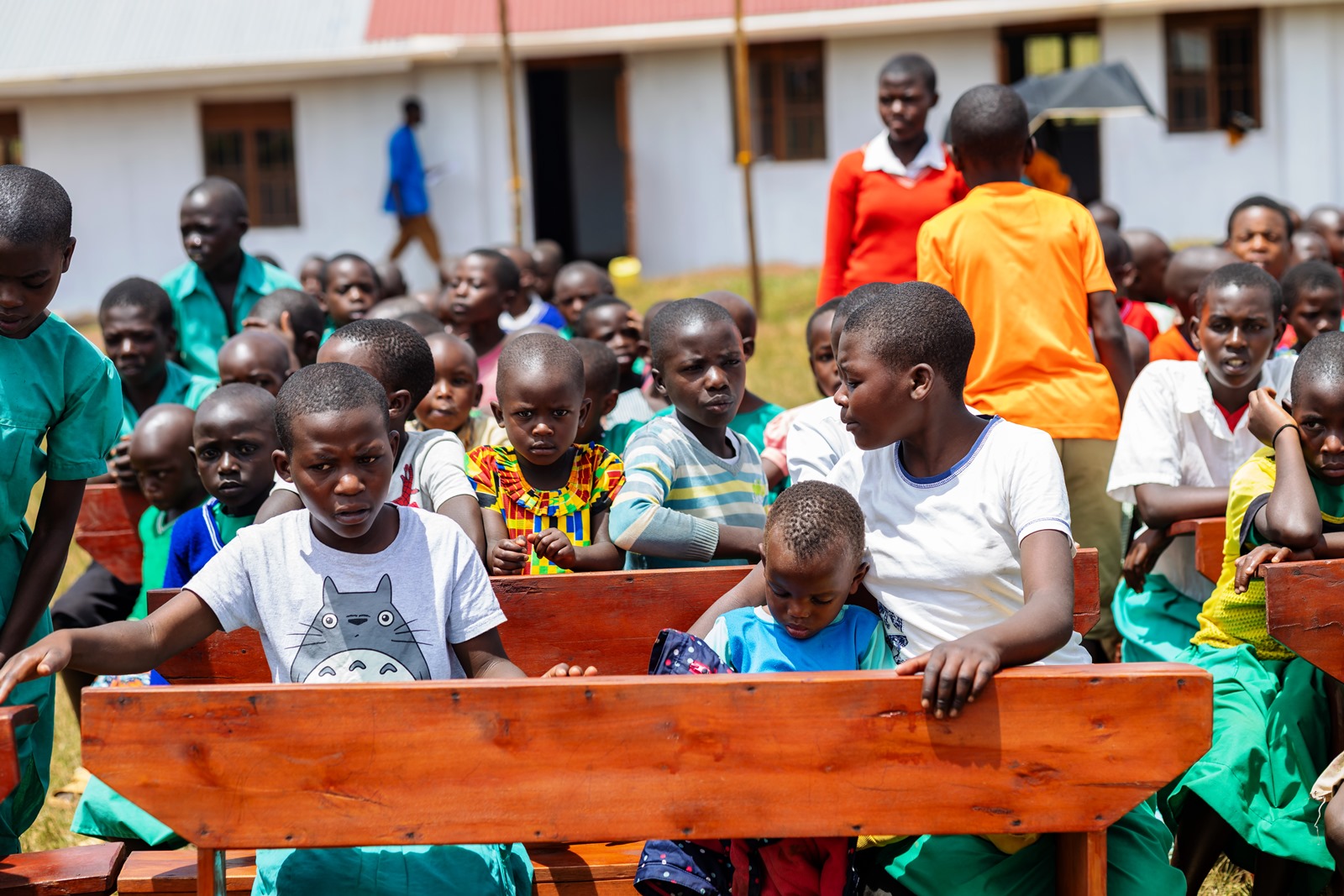 Pupils seated on some of the desks. Mastercard Foundation Scholars Program at Makerere University Giveback, in partnership with dfcu Bank, handover five-classroom block equipped with 60 bench desks, four-stance modern pit latrine, and a 10,000-litre rainwater harvesting system on 1st April 2026 to Bwera Primary School in Kabale District, Uganda, East Africa.
