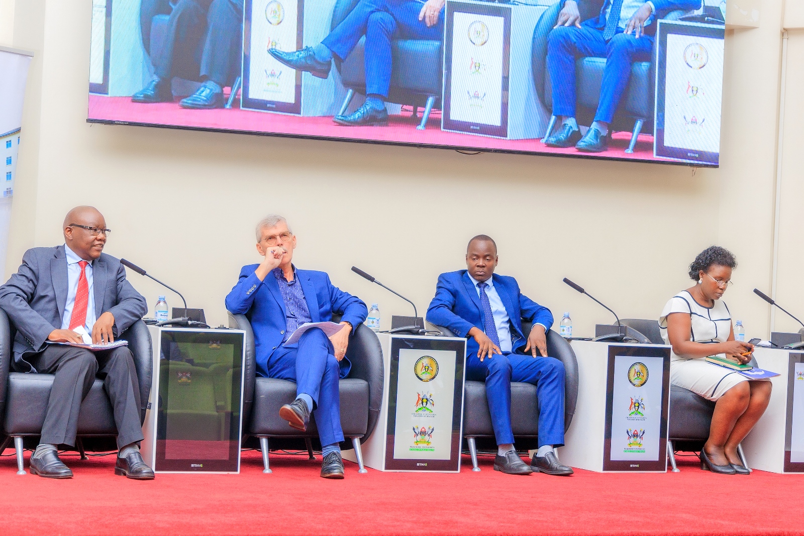 Freddie Ssengooba, a Professor of Health Economics and Health Systems Management, MakSPH, (Left) speaks during the dialogue. Listening in, Dr. Ian Clarke, NSSF’s Omojong, and the Moderator, Prof. Elizabeth Ekirapa. Public lecture and high-level dialogue on health financing organised by Makerere University School of Public Health (MakSPH) in collaboration with the Ministry of Health and the Ministry of Finance, Planning, and Economic Development, Keynote: Dr. Ramathan Ggoobi, PSST, Theme “Investing in Health for Uganda’s Future: Delivering Vision 2040 through Smart and Sustainable Health Financing”, 9th April 2026, MakSPH Auditorium, Main Campus, Kampala Uganda, East Africa.