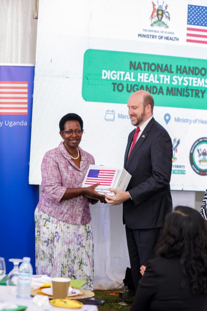 Ambassador Popp hands over tablets to MoH Permanent Secretary Dr. Diana Atwine at the Ministry of Health headquarters in Kampala. Transition of Uganda’s digital health systems and assets built over 15 years through the Makerere University School of Public Health Monitoring and Evaluation Technical Support (MakSPH-METS) Program with funding from the U.S. Government to the Ministry of Health (MoH), 31st March 2026, MoH Headquarters, Kampala Uganda, East Africa.