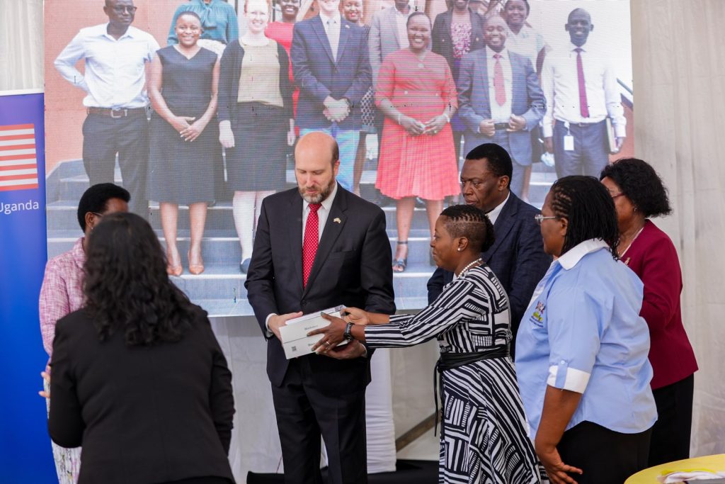 CDC Country Director, Dr. Mary A. Boyd hands over tablets to the Ambassador for the ceremonial handover. Transition of Uganda’s digital health systems and assets built over 15 years through the Makerere University School of Public Health Monitoring and Evaluation Technical Support (MakSPH-METS) Program with funding from the U.S. Government to the Ministry of Health (MoH), 31st March 2026, MoH Headquarters, Kampala Uganda, East Africa.
