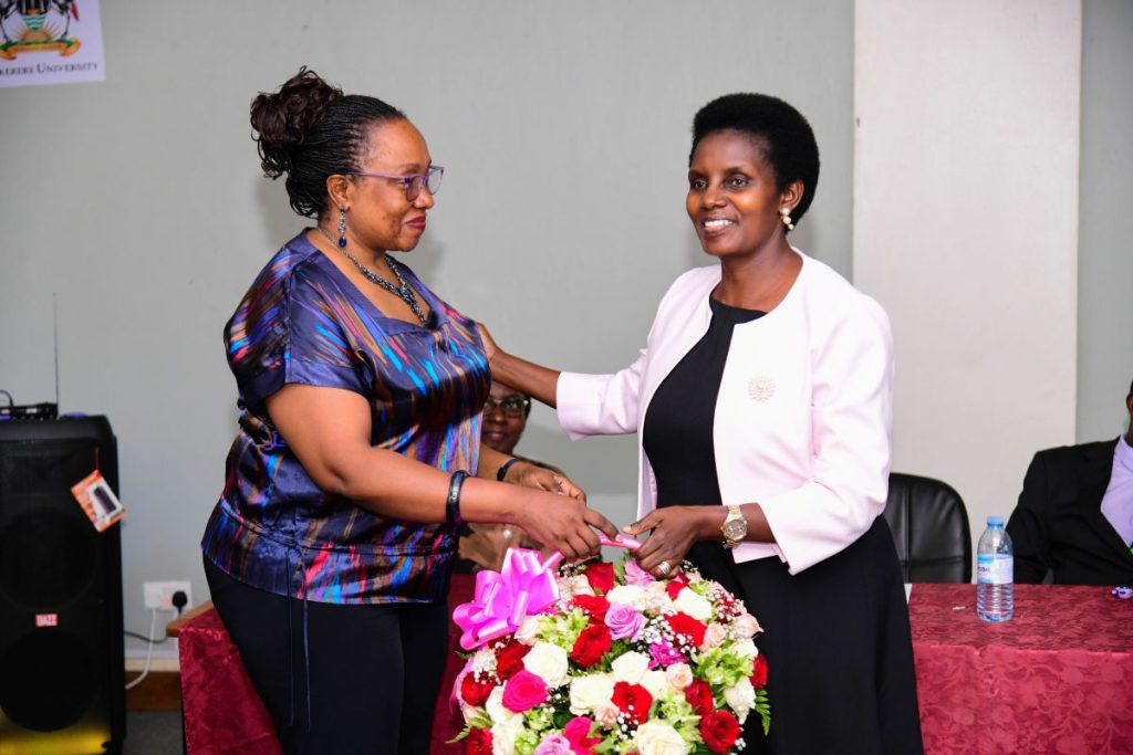 Mrs. Mushengyezi receiving a bouquet of flowers from Ms. Ruth Iteu Eyoku