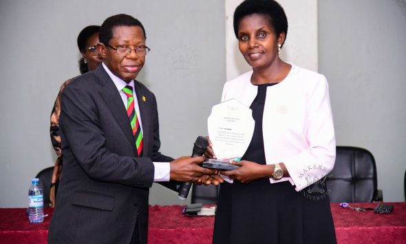 Academic Registrar Prof. Mukadasi Buyinza handing over a plaque in appreciation of Mrs. Patience Rubabinda Mushengyezi.