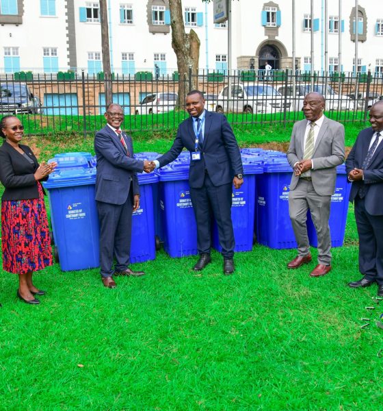 Prof. Barnabas Nawangwe (3rd L) shakes hands with Centenary Bank's Mr. Sunday Julius (C) as L-R: Mr. Simon Kizito, Prof. Sarah Ssali, Prof. Henry Alinaitwe, Mr. Paul Agaba and SSP Kaheebwa Geoffrey applaud on 11th May 2026. Donation of 30 waste bins by Centenary Bank’s Makerere Branch as part of ESG objectives, 11th May 2026, Freedom Square, Makerere University, Kampala Uganda.