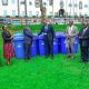Prof. Barnabas Nawangwe (3rd L) shakes hands with Centenary Bank's Mr. Sunday Julius (C) as L-R: Mr. Simon Kizito, Prof. Sarah Ssali, Prof. Henry Alinaitwe, Mr. Paul Agaba and SSP Kaheebwa Geoffrey applaud on 11th May 2026. Donation of 30 waste bins by Centenary Bank’s Makerere Branch as part of ESG objectives, 11th May 2026, Freedom Square, Makerere University, Kampala Uganda.