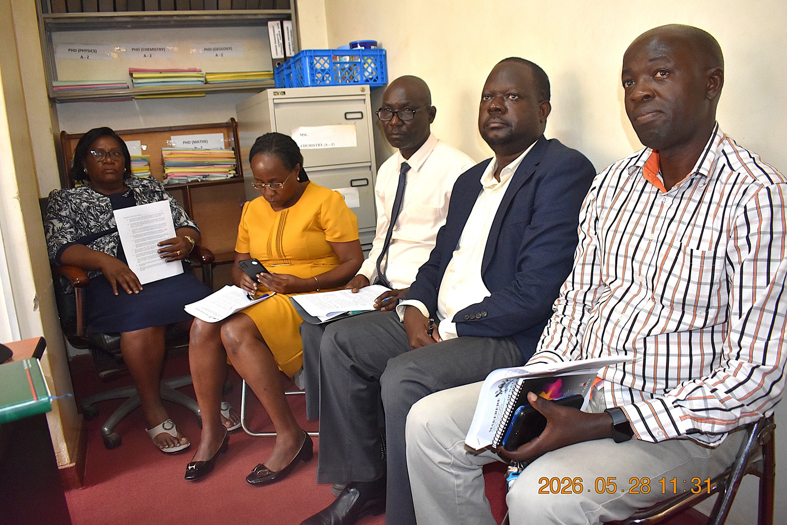 Right-Left: Dr. Nicholas Kwarikunda from the Department of Physics, Prof. David Ssevviiri, Mr. Patrick Akonyet, Ms. Hellen Mirembe, Registrar, School of Physical Sciences, and Ms. Joyce Nyiramahoro, College Registrar. Prof. Michael Owor officially hands over office of Dean, School of Physical Sciences to Prof. David Ssevviiri for the next four years, effective 6th May 2026, on 28th May 2026, College of Natural Sciences (CoNAS), Makerere University, Kampala Uganda, East Africa.