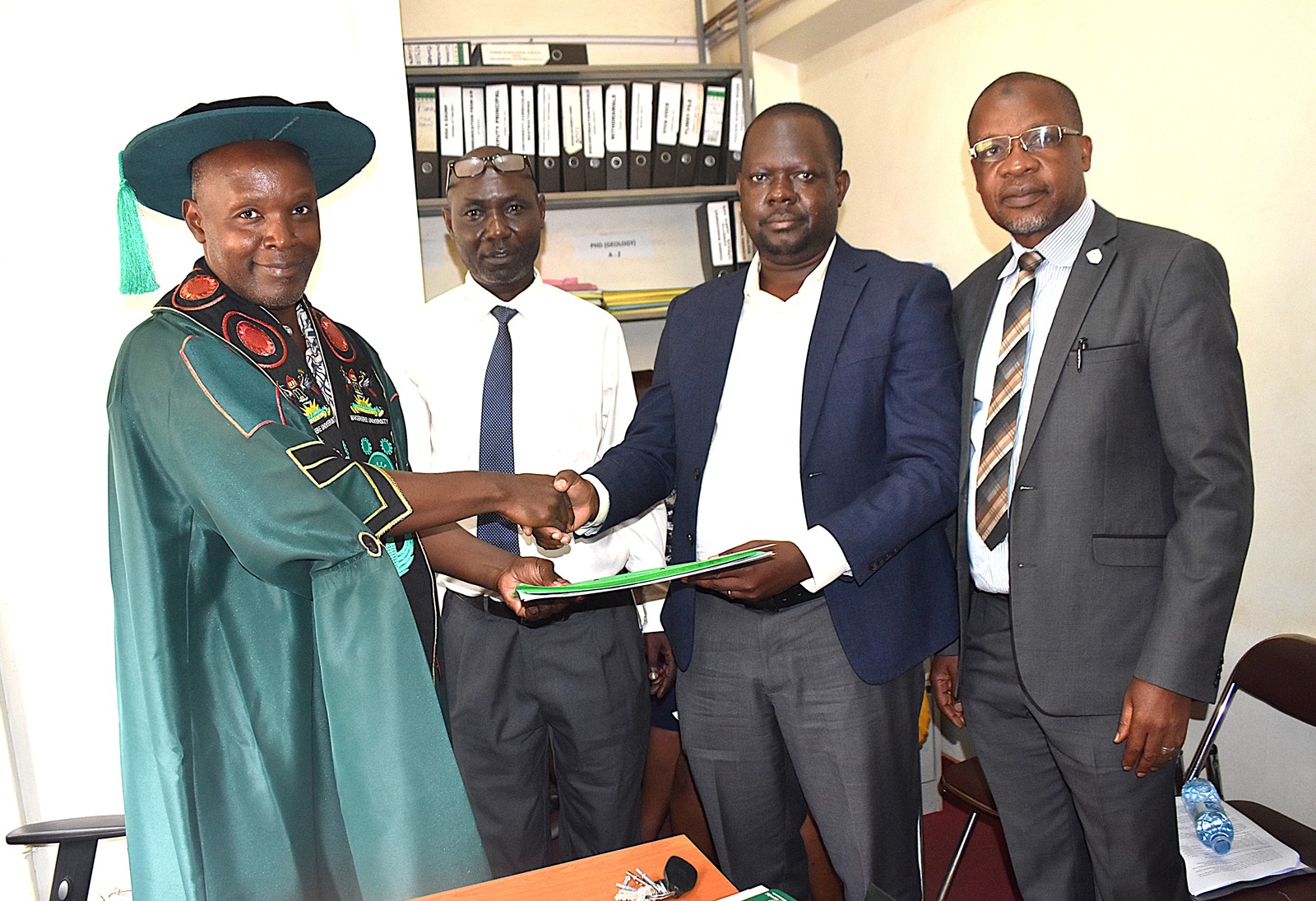 Prof. Michael Owor (L) handing over to Prof. David Ssevviiri. Second left is Makerere University Chief of Internal Audit, Mr Patrick Akonyet and on the right is Prof. Juma Kasozi, Deputy Principal, CoNAS. Prof. Michael Owor officially hands over office of Dean, School of Physical Sciences to Prof. David Ssevviiri for the next four years, effective 6th May 2026, on 28th May 2026, College of Natural Sciences (CoNAS), Makerere University, Kampala Uganda, East Africa.
