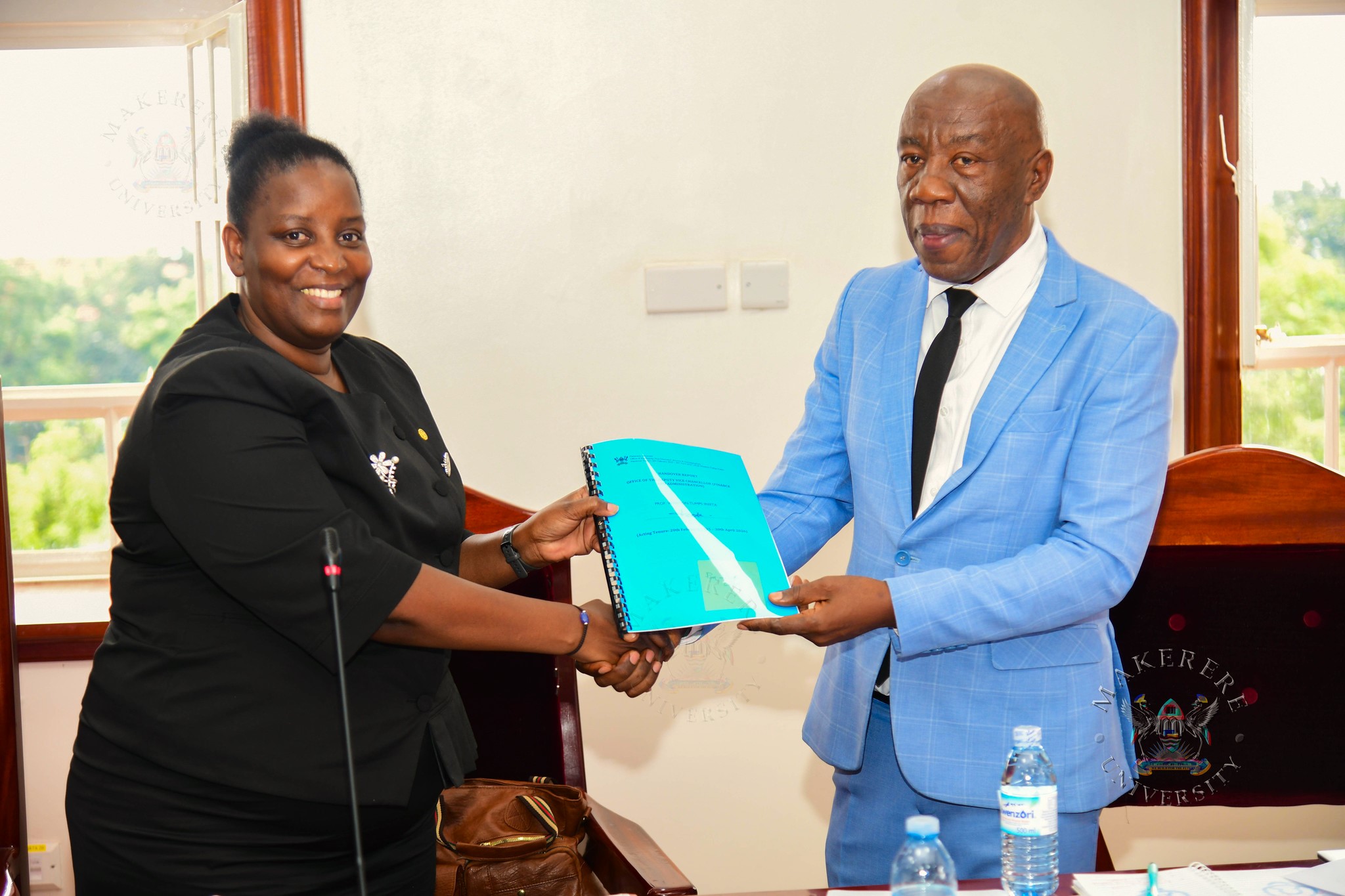 Prof. Nambalirwa Nkabala (L) presents the handover report to Prof. Henry Alinaitwe. Handover of Office of Deputy Vice Chancellor (Finance and Administration)-DVCFA from Prof. Winston Tumps Ireeta to Prof. Henry Alinaitwe, 4th May 2026, Council Room, Main Building, Makerere University, Kampala Uganda, East Africa.