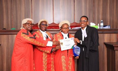 L-R: The presiding judges - Hon Justice Isa Serunkuma, Hon. Lady Justice Jane Okuo Kajuga, Hon Lady Justice Alice Komuhangi Khauka with Mayanja Owen who was named the best oralist at the moot competition. Public Interest Law (PILAC) 13th Clinical Legal Education (CLE) Moot presided over by a panel of three High Court Judges: Hon. Lady Justice Jane Okuo Kajuga, Hon. Justice Isa Serunkuma and Hon. Lady Justice Alice Komuhangi Khaukha, 14th May 2026, in the Makerere University School of Law (SoL) Moot Court Room, Kampala Uganda, East Africa.