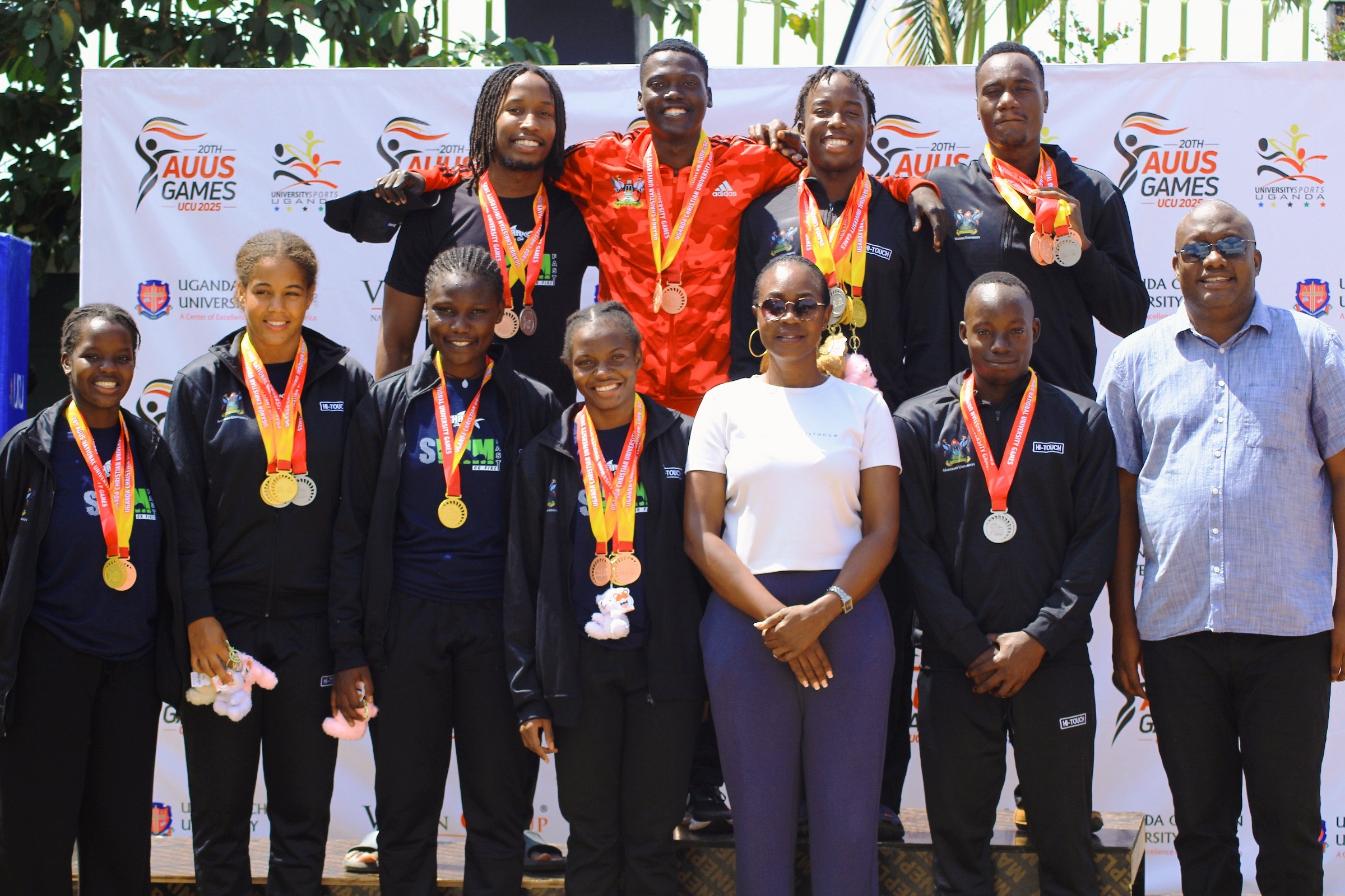 The Dean of Students-Dr. Winifred Kabumbuli (3rd R) and Principal Sports Tutor-Mr. Brian Miiro (R) at the podium with Mak Sharks Team Members that claimed both best overall trophies for the Men and Ladies categories at the AUUS Games in December 2025. Making Waves: The Rise of the Mak Sharks and Makerere University's Aquatic Legacy, Swimming, Kampala Uganda, East Africa.