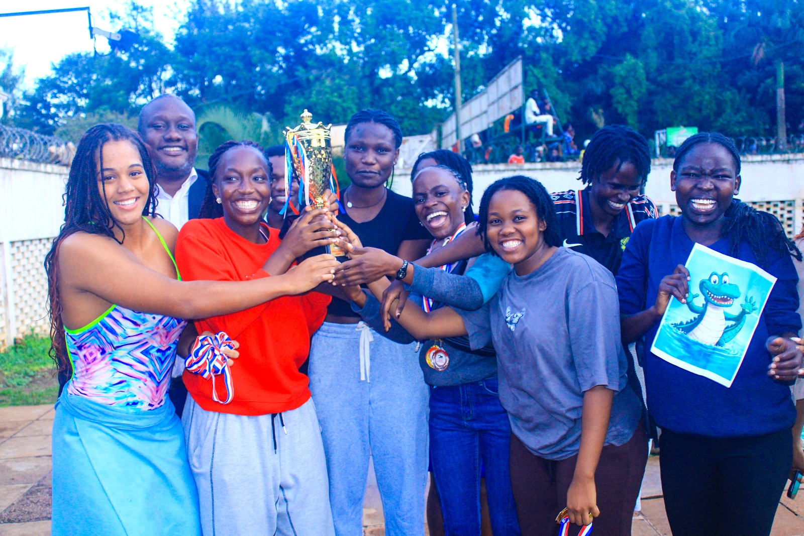 Mr. Brian Miiro (Background) with CCE/Complex Hall Swimmers that emerged Overall Winners in the girls' category at the Inter-Hall Swimming Championships held 17th April 2026. The Inter-Hall Swimming Championships, 17th April 2026, Makerere University Pool, Kampala Uganda, East Africa. Photos: Patrick Kawaii Instagram/WabwireJr