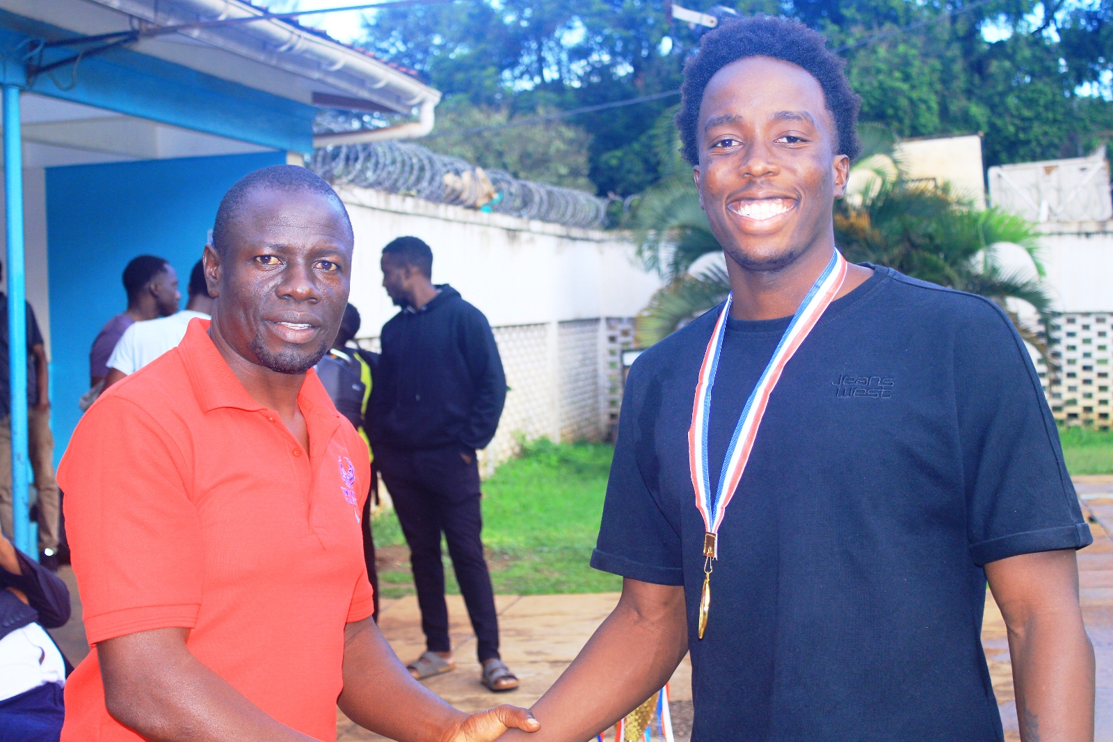 Sports Tutor-Mr. Ssenkungu James (Left) congratulates Ampaire Nimusiima Namanya on his outstanding performance. The Inter-Hall Swimming Championships, 17th April 2026, Makerere University Pool, Kampala Uganda, East Africa. Photos: Patrick Kawaii Instagram/WabwireJr