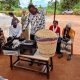 Dr. Patrick Musinguzi, the TORCH Project PI, showcasing the Gas Chambers for measuring GHGs emitted from the soil and animal waste, a portable improved energy cooking stove, and a food warming basket. Towards a Clean Energy and Zero-Emission Society in East Africa: Strengthening Academic and Community Collaboration in Outreach, Training, and Research for Green Growth and a Healthy Environment (TORCH) Project Living Lab model project engagement, 4th May 2026 in Kawumu Village, Luwero District Uganda, East Africa with participation from Makerere University, BOKU University (Austria), Kabale University, academia, local communities, civil society, and international institutions.