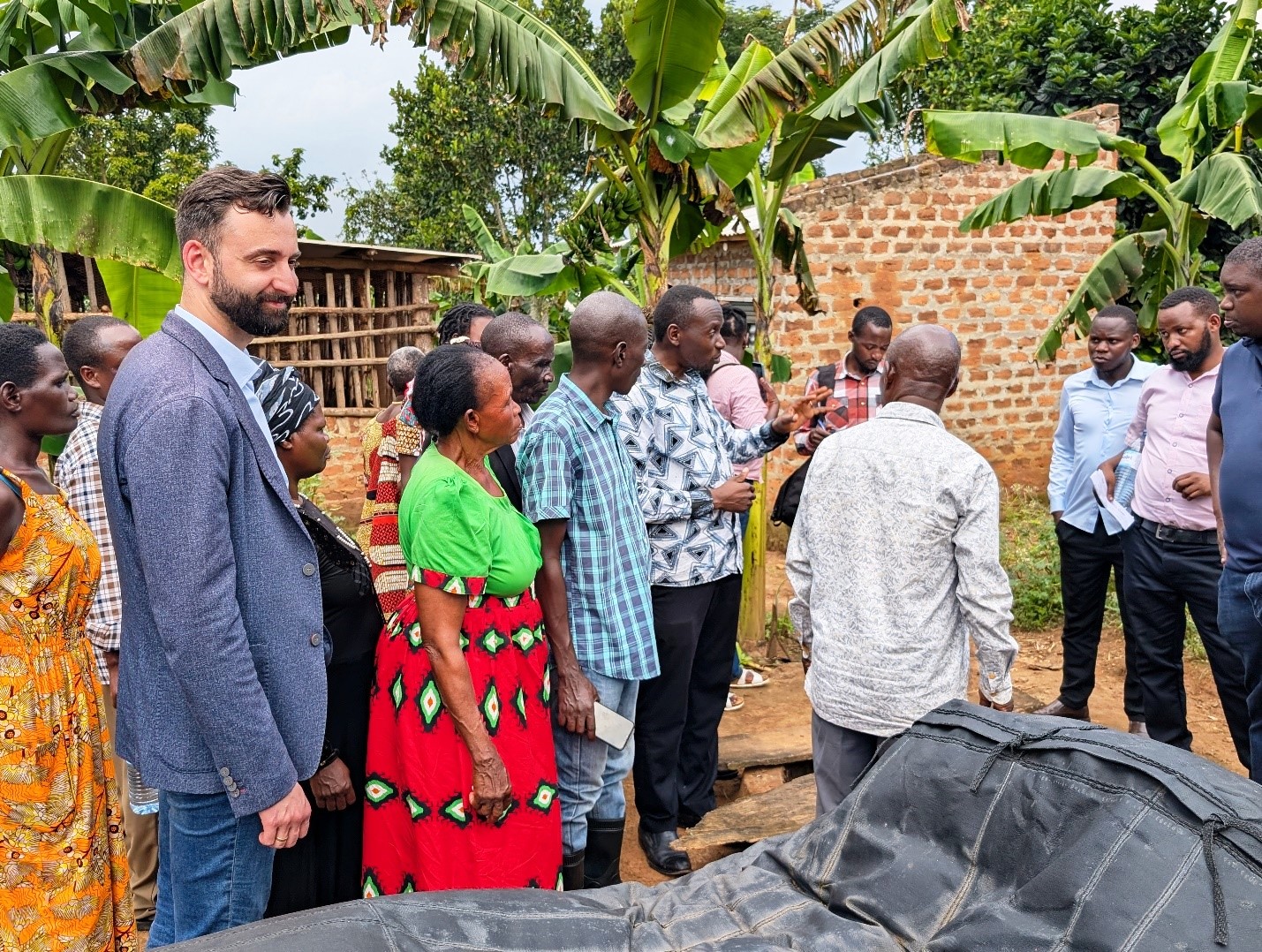Dr. Patrick Musinguzi demonstrating how the Biogas system works in converting animal waste into clean energy for cooking. Towards a Clean Energy and Zero-Emission Society in East Africa: Strengthening Academic and Community Collaboration in Outreach, Training, and Research for Green Growth and a Healthy Environment (TORCH) Project Living Lab model project engagement, 4th May 2026 in Kawumu Village, Luwero District Uganda, East Africa with participation from Makerere University, BOKU University (Austria), Kabale University, academia, local communities, civil society, and international institutions.