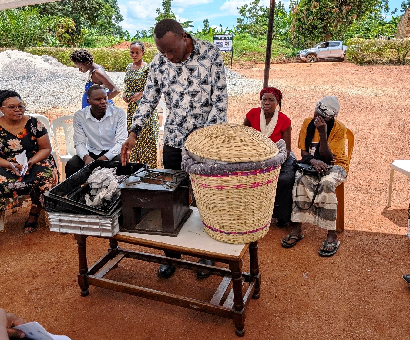 Dr. Patrick Musinguzi, the TORCH Project PI, showcasing the Gas Chambers for measuring GHGs emitted from the soil and animal waste, a portable improved energy cooking stove, and a food warming basket. Towards a Clean Energy and Zero-Emission Society in East Africa: Strengthening Academic and Community Collaboration in Outreach, Training, and Research for Green Growth and a Healthy Environment (TORCH) Project Living Lab model project engagement, 4th May 2026 in Kawumu Village, Luwero District Uganda, East Africa with participation from Makerere University, BOKU University (Austria), Kabale University, academia, local communities, civil society, and international institutions.