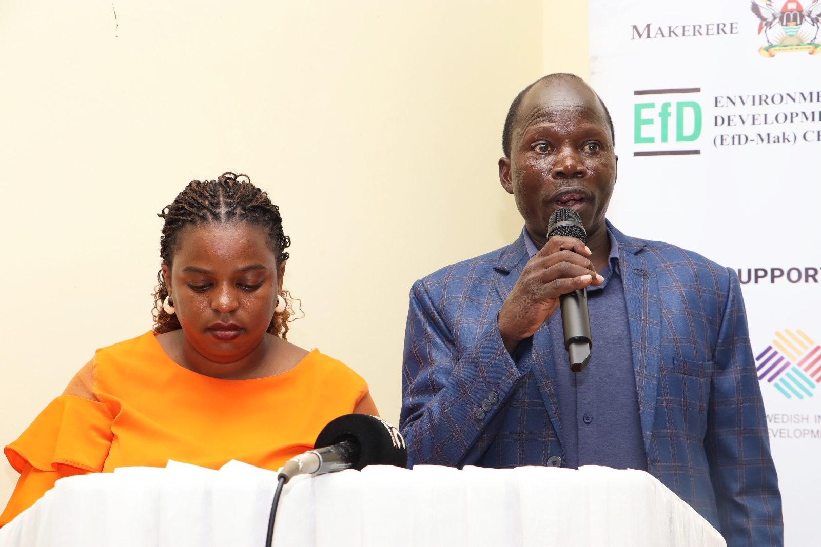 Graduands Irene Kemigisha (Left) and Eng. Epeet Thomas (Right) presenting during the ceremony. Makerere University Environment for Development Initiative (EfD- Mak Centre) graduation of five senior government officials under the 2025 Inclusive Green Economy (IGE) Fellowship Programme, equipping them with advanced knowledge and skills to champion climate-smart agriculture (CSA) and sustainable development in Uganda, June 25, 2026, Makerere University Agricultural Research Institute, Kabanyolo (MUARIK), Wakiso, East Africa.