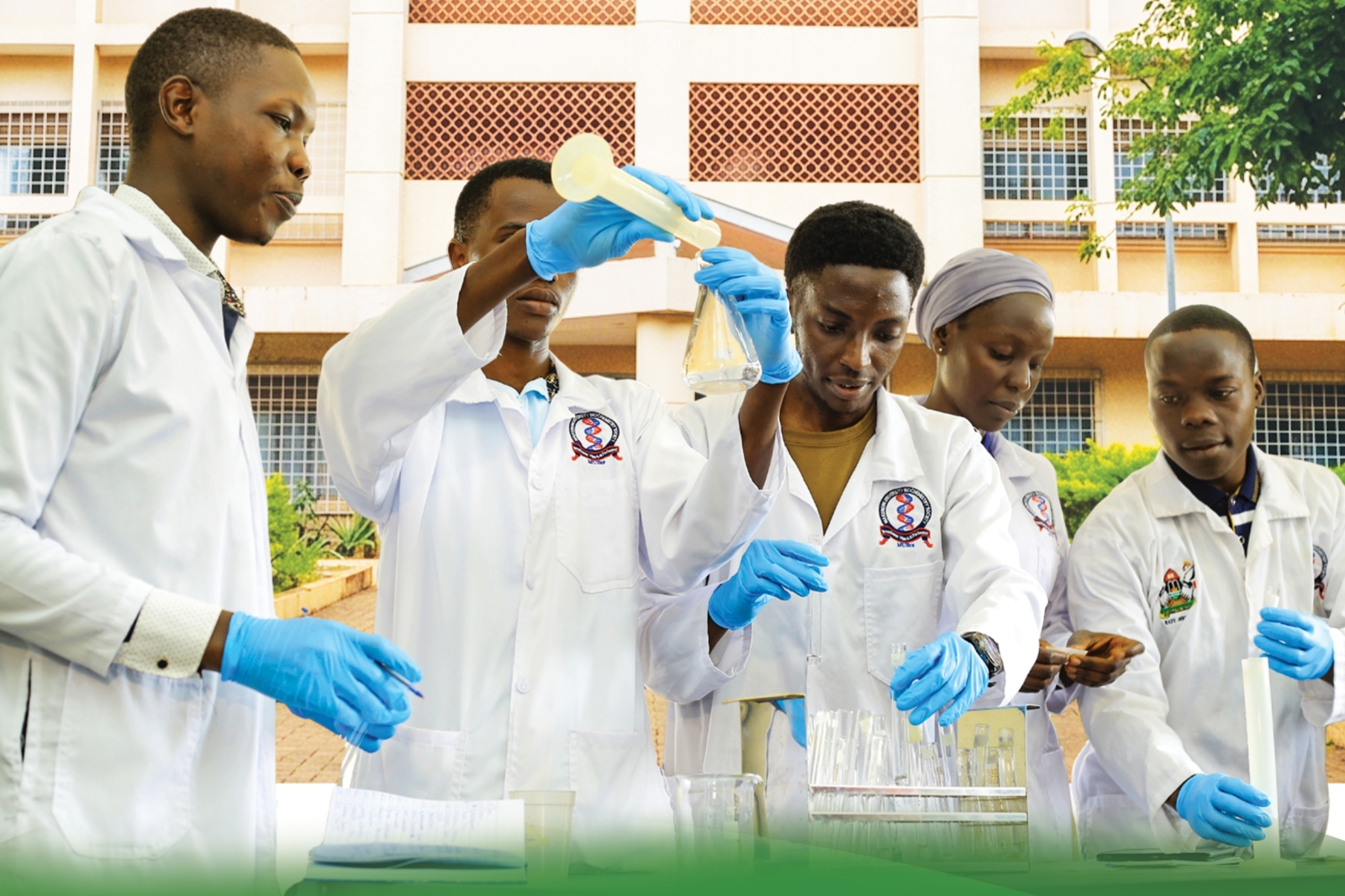 Cover page of the College of Natural Sciences (CoNAS) Annual Report 2025. Depicting Students in a lab with the JICA Building as a background image, Makerere University, Kampala Uganda, East Africa.