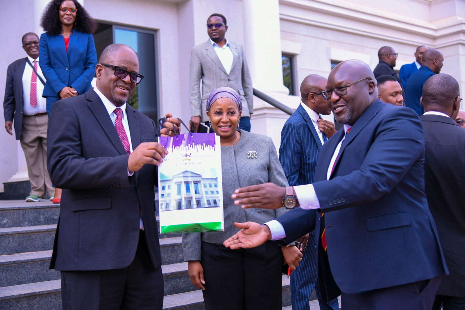 Hon. Justice Dr. Malila (L) receives SoL Souvenirs from Prof. Naluwairo (R) as Dr. Nampewo (C) witnesses. Courtesy Visit of the Chief Justice of the Republic of Zambia, Hon. Justice Dr. Mumba Malila and the Chief Justice of Uganda, Hon. Justice Dr. Flavian Zeija on sidelines of the African Chief Justices' Forum on Alternative Dispute Resolution (ADR) leadership handover ceremony, 16th June 2026, Makerere University, Kampala Uganda.