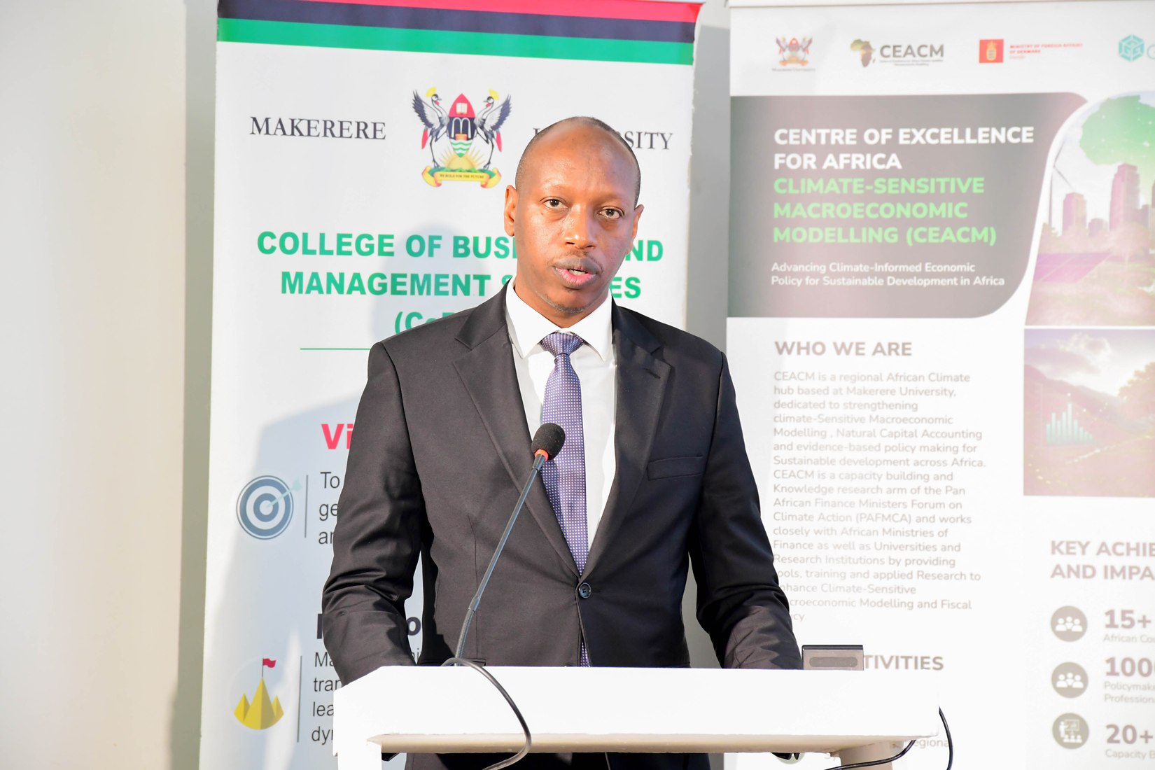 Mr. Davis Vuningoma, Acting Commissioner for Macroeconomic Policy at Uganda’s Ministry of Finance, Planning and Economic Development, addressing participants. Launch of Policy Briefs developed by the Centre of Excellence for Africa Climate-Sensitive Macroeconomic Modelling (CEACM), College of Business and Management Sciences (CoBAMS), 15th July 2026, Senior Common Room, Main Building, Makerere University, Kampala Uganda, East Africa.