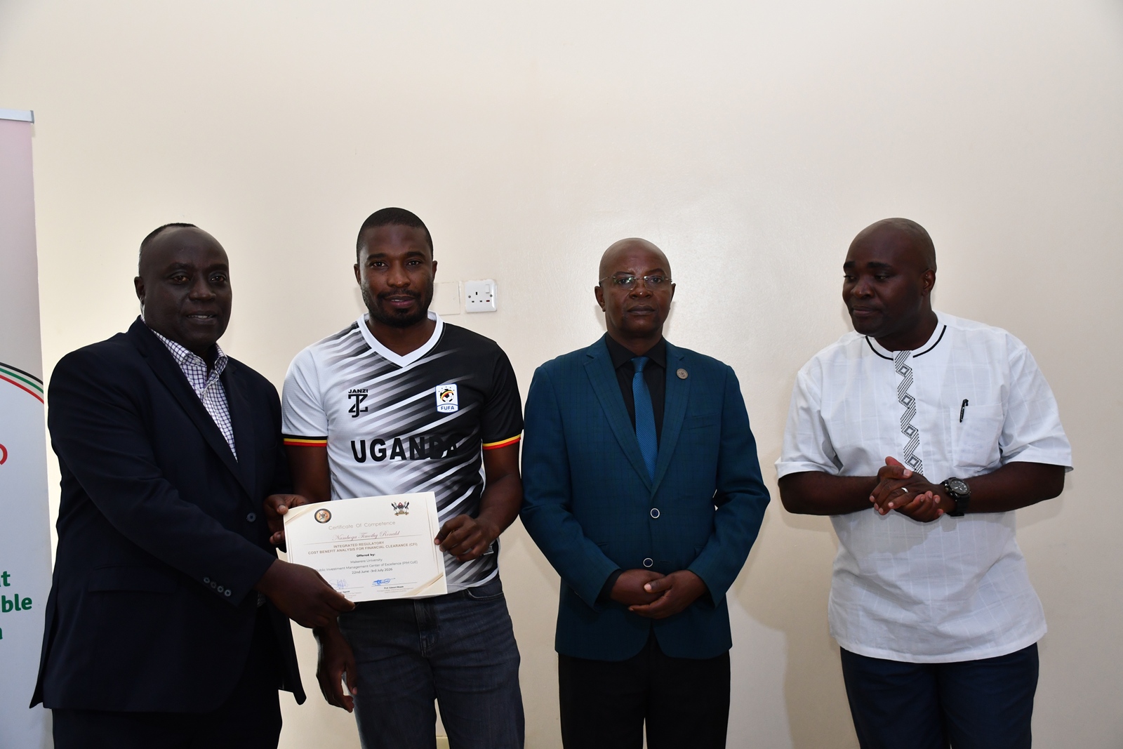 Mr. Henry Mwanja, Prof. Edward Bbaale and Dr. John Sseruyange present a certificate to Mr. Namboga Timothy Ronald (2nd L). Public Investment Management Centre of Excellence (PIM CoE), Makerere University, Kampala in partnership with the Ministry of Finance, Planning and Economic Development (MoFPED) graduation of two-week training of the fourth cohort of the Capacity Enhancement and Hands-on Training on the Guidelines for Financial Clearance and the Certificate of Financial Implications (CFI) – Integrated Regulatory Cost-Benefit Analysis. 3rd July 2026, Pearl on the Nile Hotel, Jinja, Uganda, East Africa.
