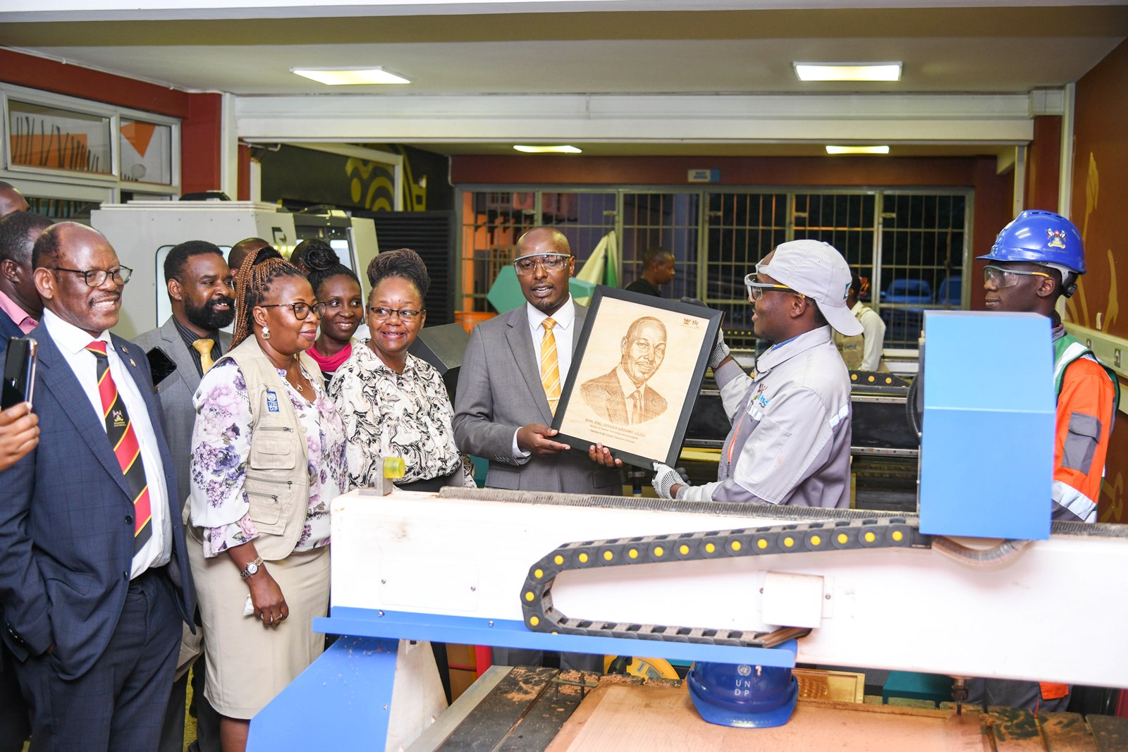 Hon. Eng. Jonard Asiimwe Akiiki receives a portrait produced by pyrography during his visit to the Mak UniPod. Hon. Eng. Jonard Asiimwe Akiiki, Minister of Science, Technology and Innovation in the Office of the President, two-day Ministerial Maiden Visit to Makerere University, 21st-22nd July 2026, Kampala Uganda, East Africa.