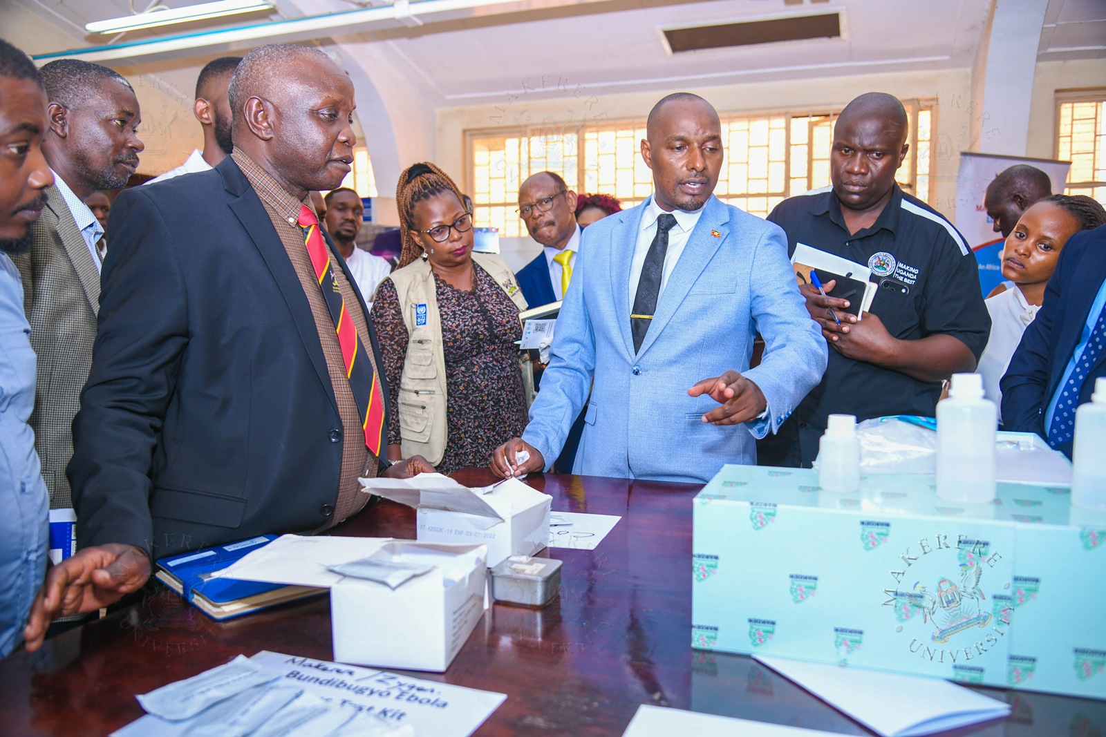 Hon. Eng. Jonard Asiimwe Akiiki interacts with Prof. Moses Joloba during a tour of the exhibition. Hon. Eng. Jonard Asiimwe Akiiki, Minister of Science, Technology and Innovation in the Office of the President, two-day Ministerial Maiden Visit to Makerere University, 21st-22nd July 2026, Kampala Uganda, East Africa.